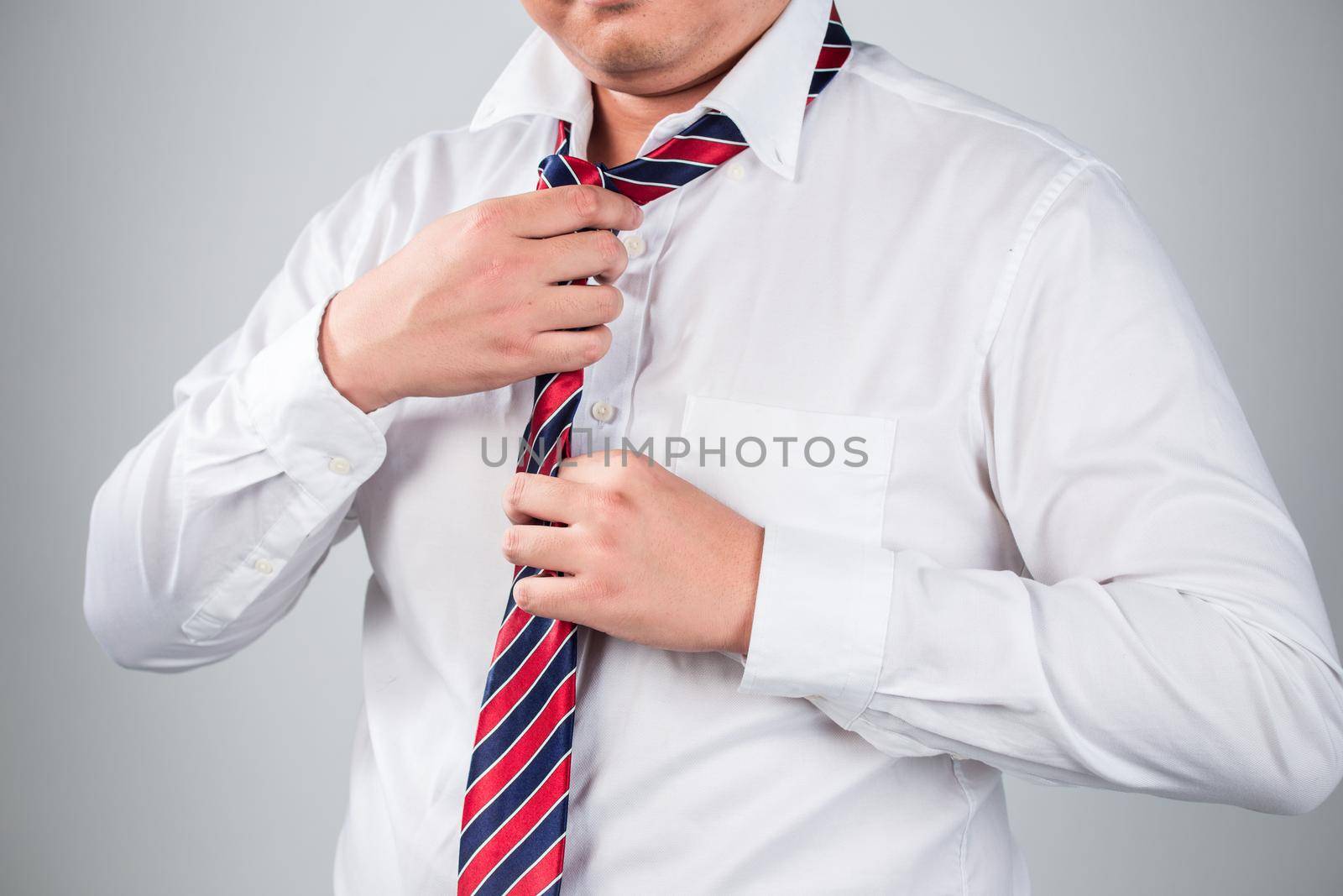 Businessman in blue suit tying the necktie good