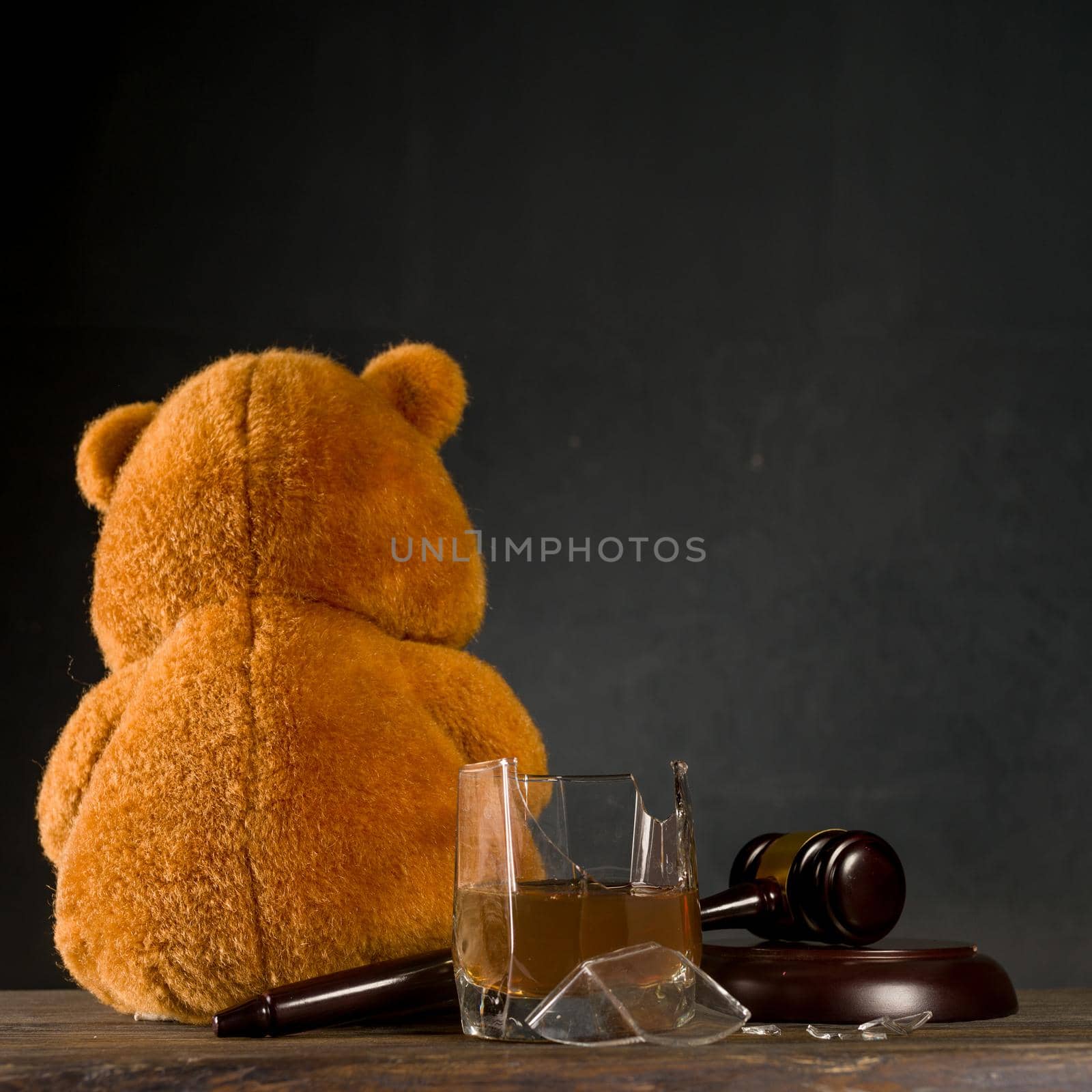 Teddy bear, judge's hammer, broken glass. The concept of deprivation of parental rights or divorce due to alcoholism. - image