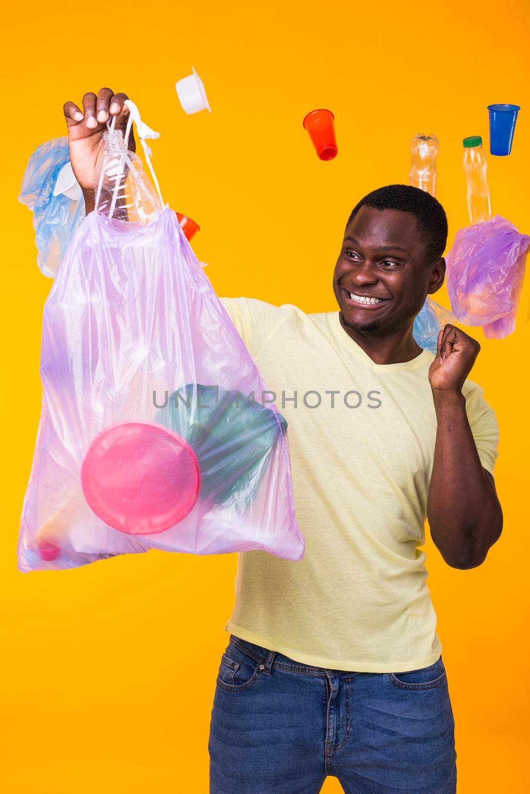 Problem of trash, plastic recycling, pollution and environmental concept - funny man carrying garbage bag on yellow background by Satura86