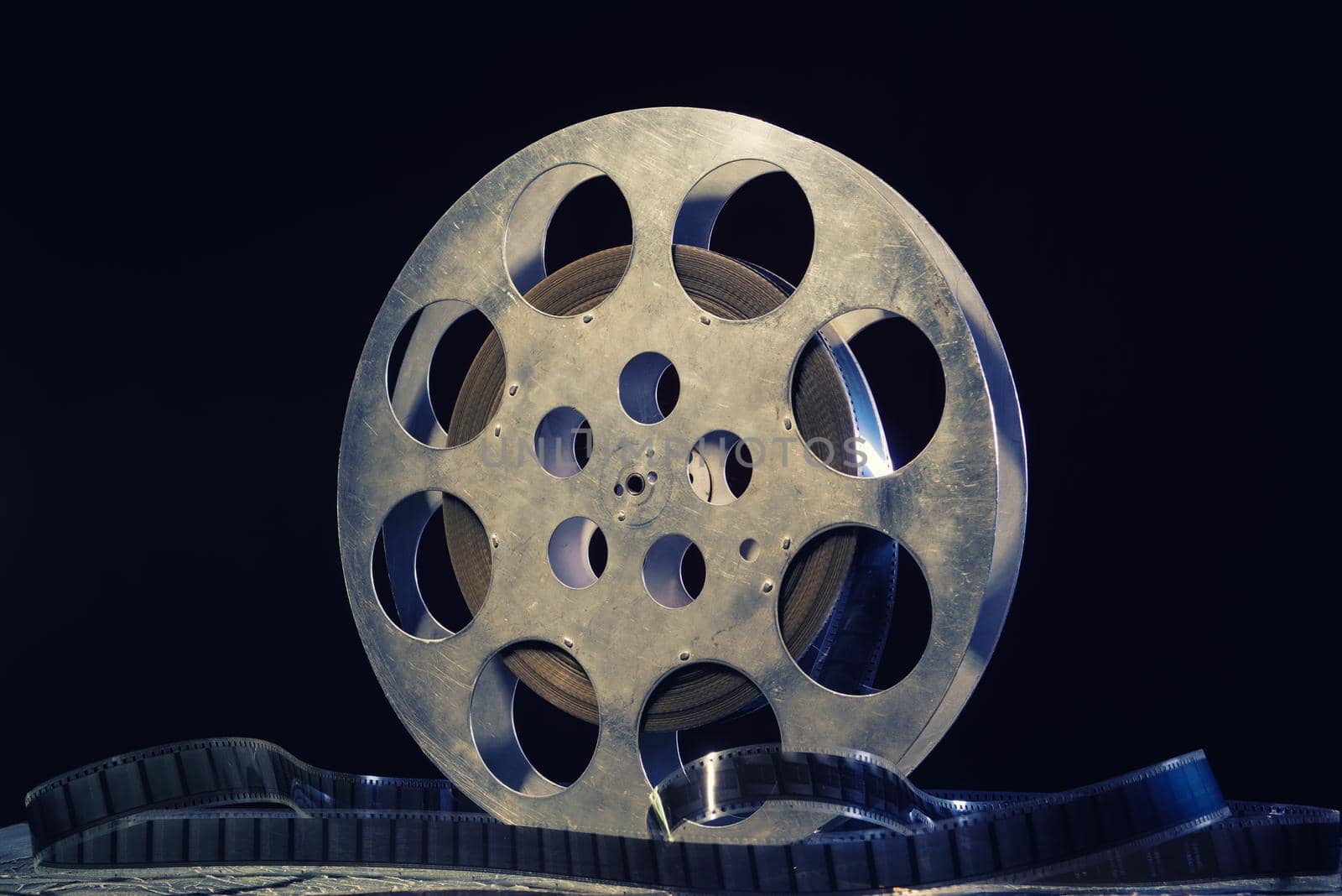 35 mm film reel with dramatic lighting on a dark background - image toned