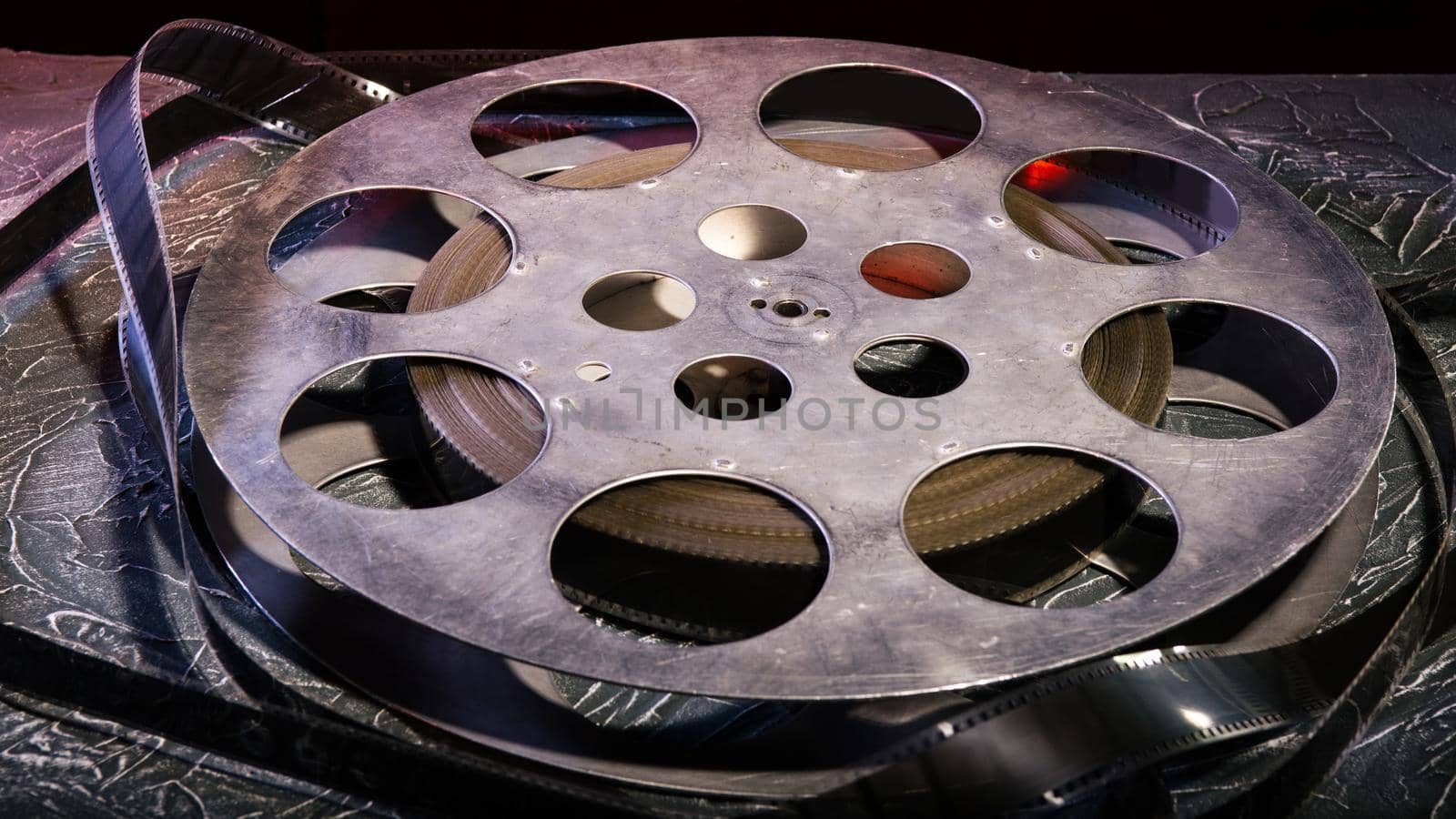 35 mm film reel with dramatic lighting on a dark background - image
