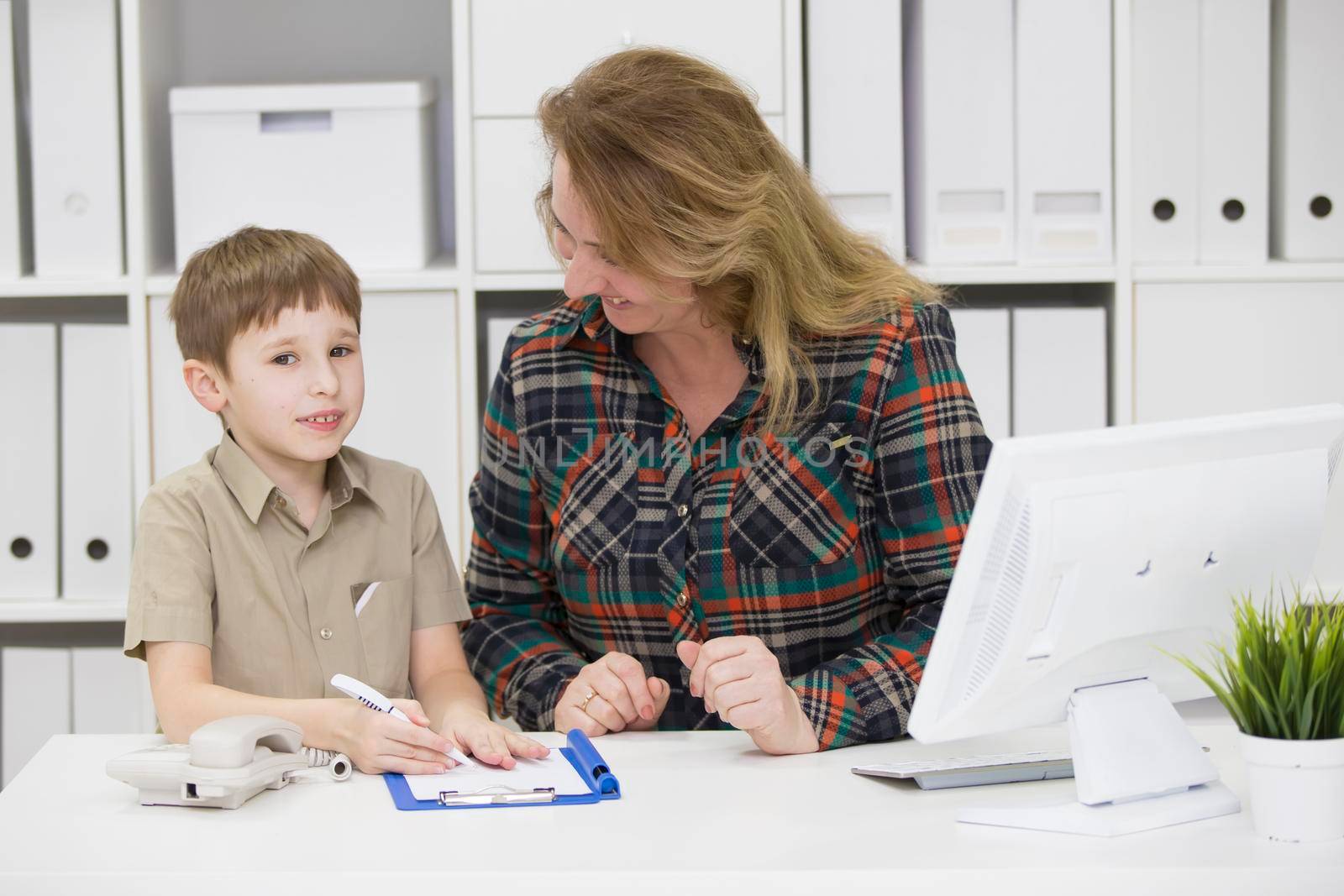 Teacher with a primary school student.Mom in the office with a child