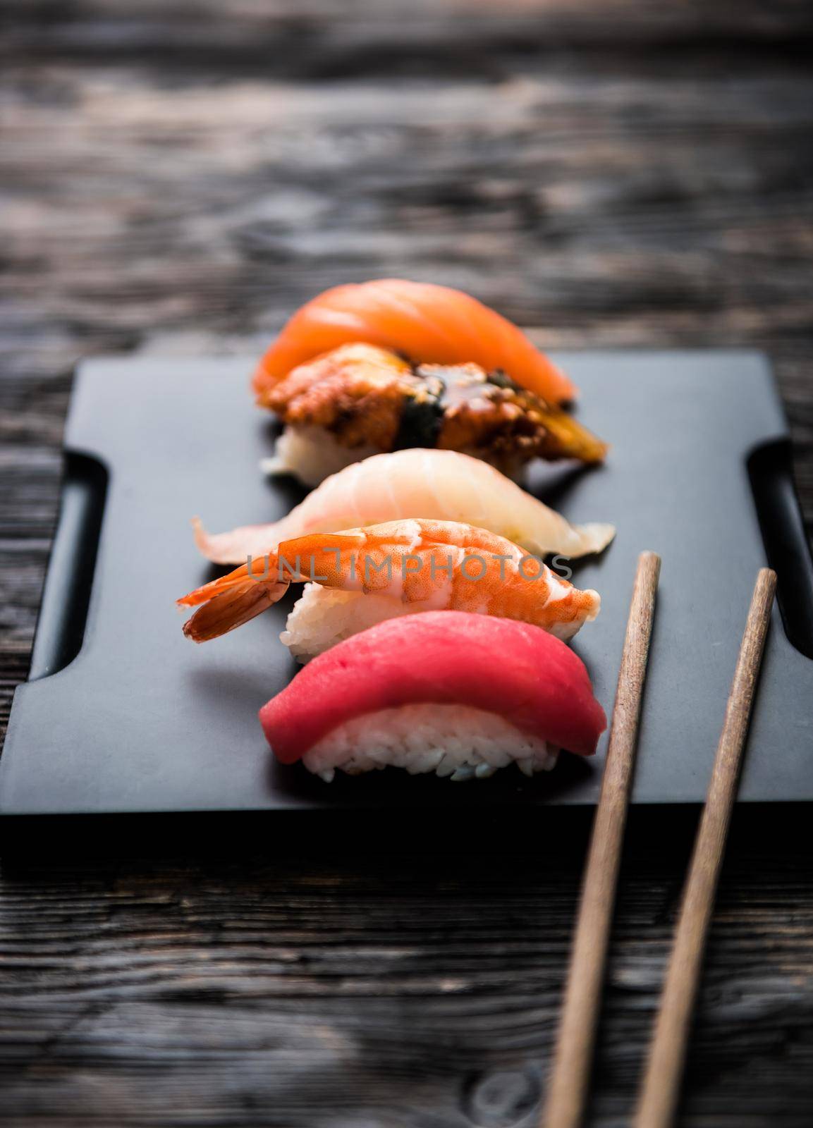 sashimi sushi set with chopsticks and soy on black background