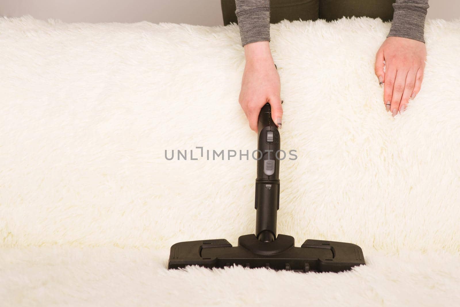 Young woman with a steam cleaner cleans the carpet on the couch - Image