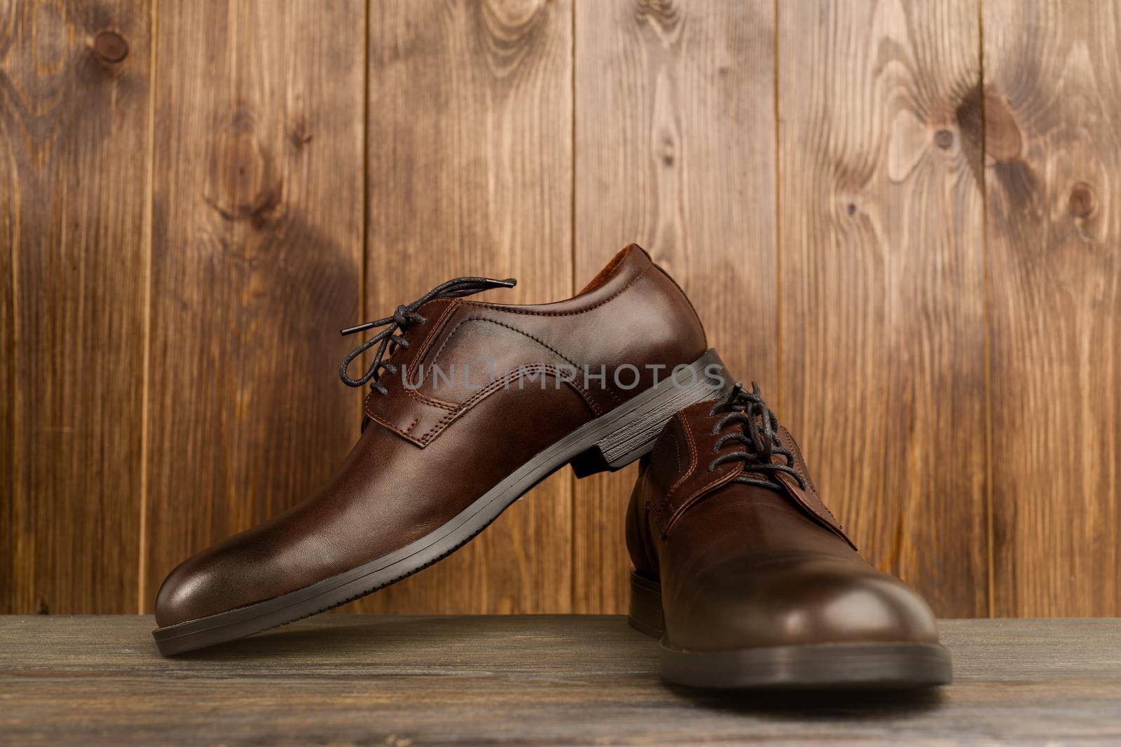 Fashionable men's classic brown shoes on a wooden background - image