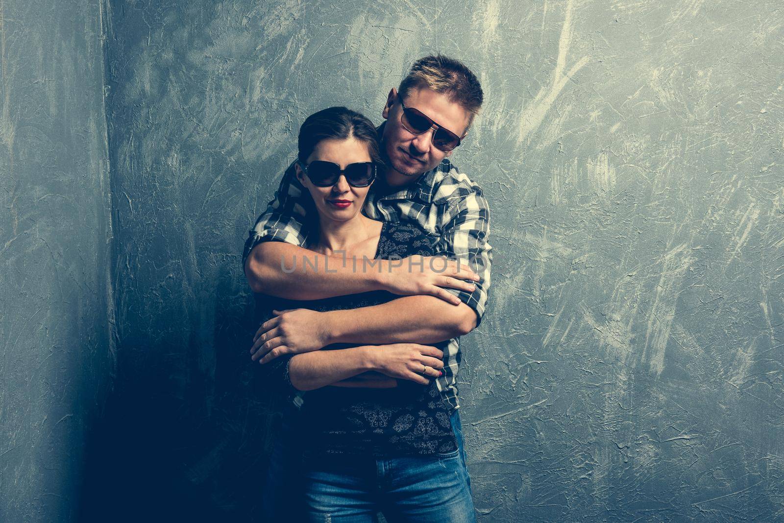couple with sunglasses on grey background