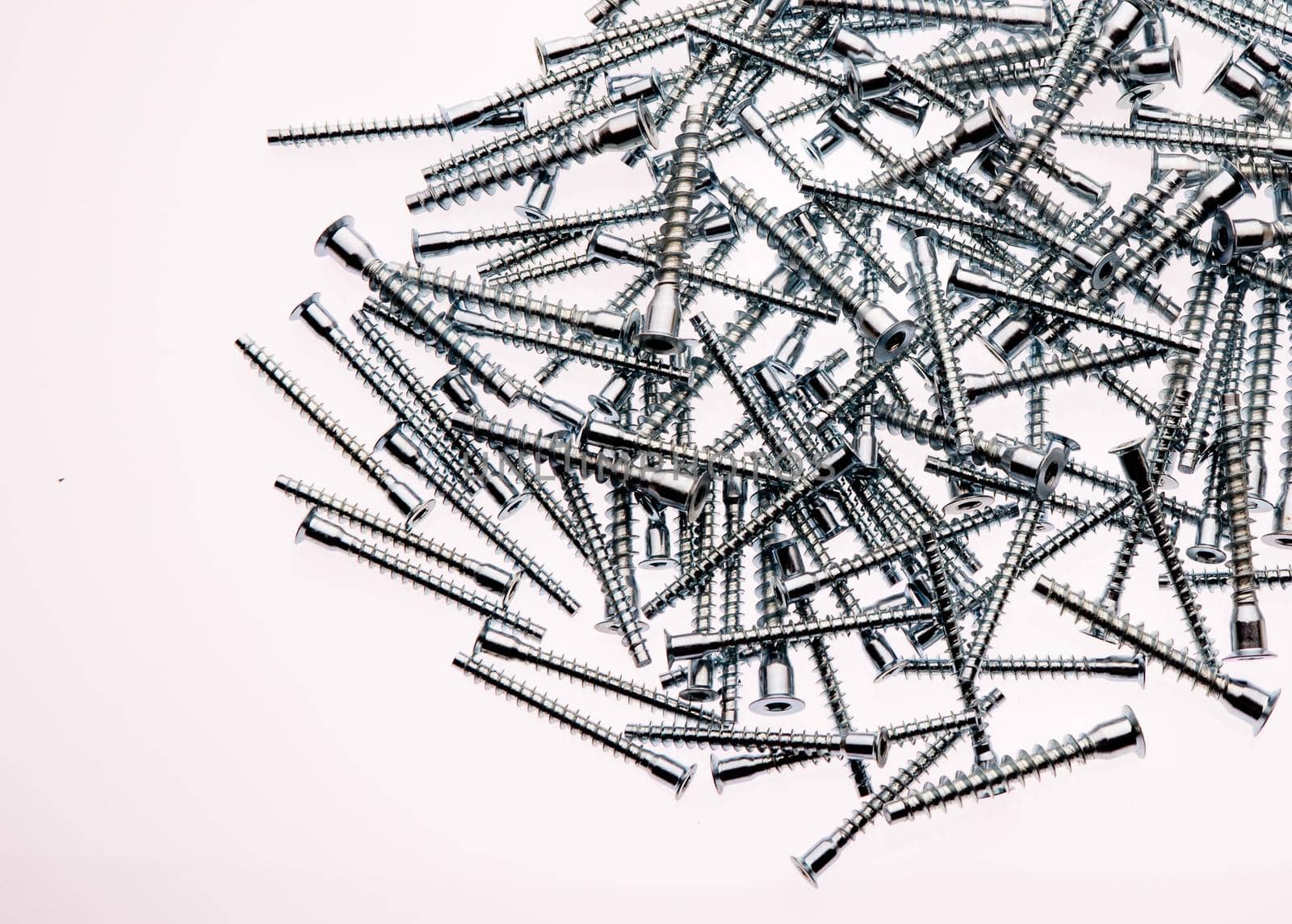 Mound of furniture screws top view on white background- image