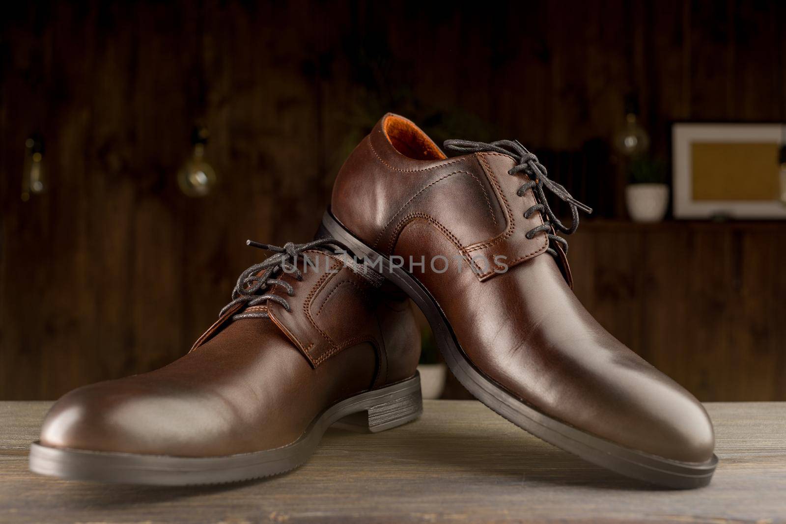Fashionable men's classic brown shoes on a wooden background - image