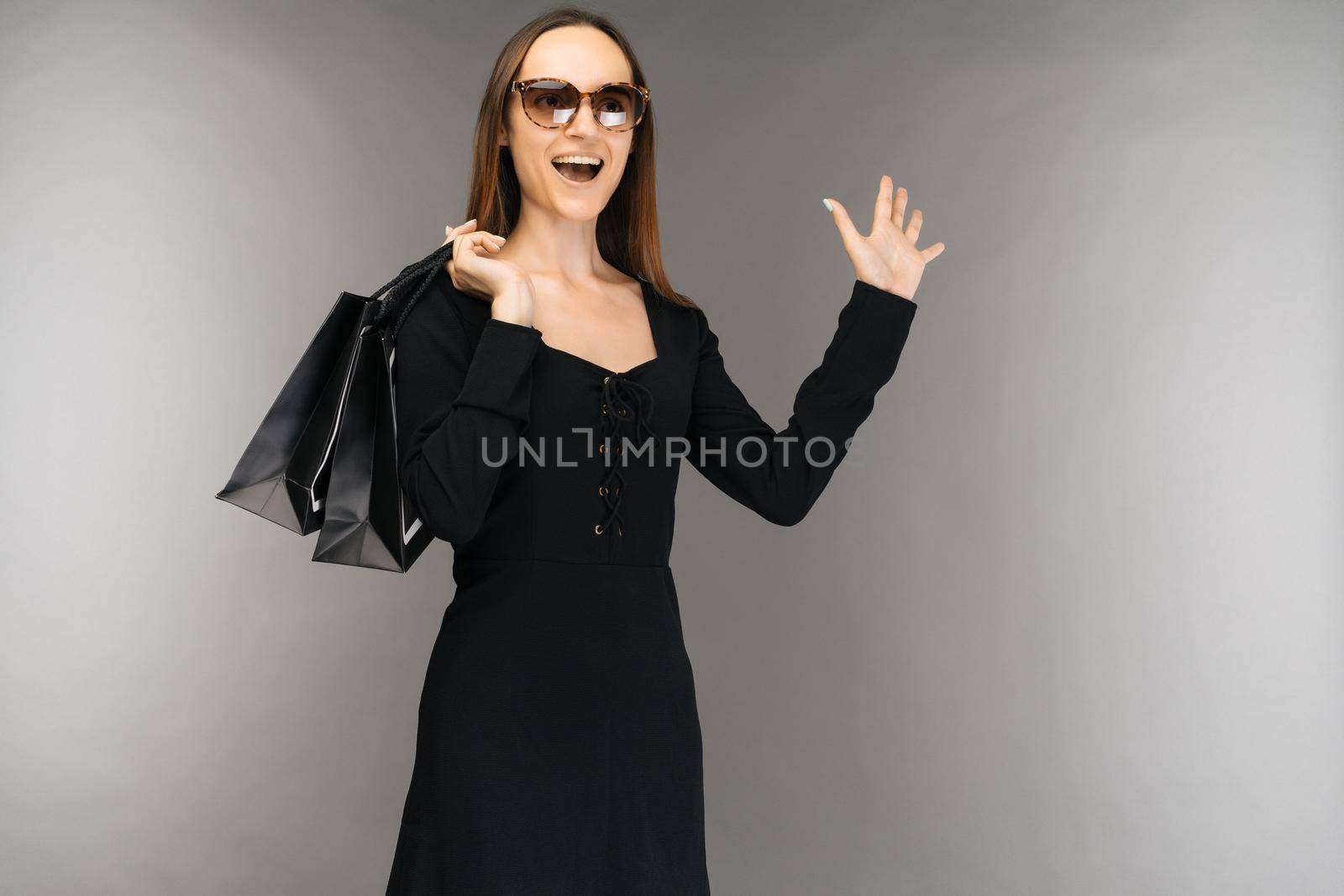 Black friday sale concept. shocked woman holding bag isolated on background in holiday - Image