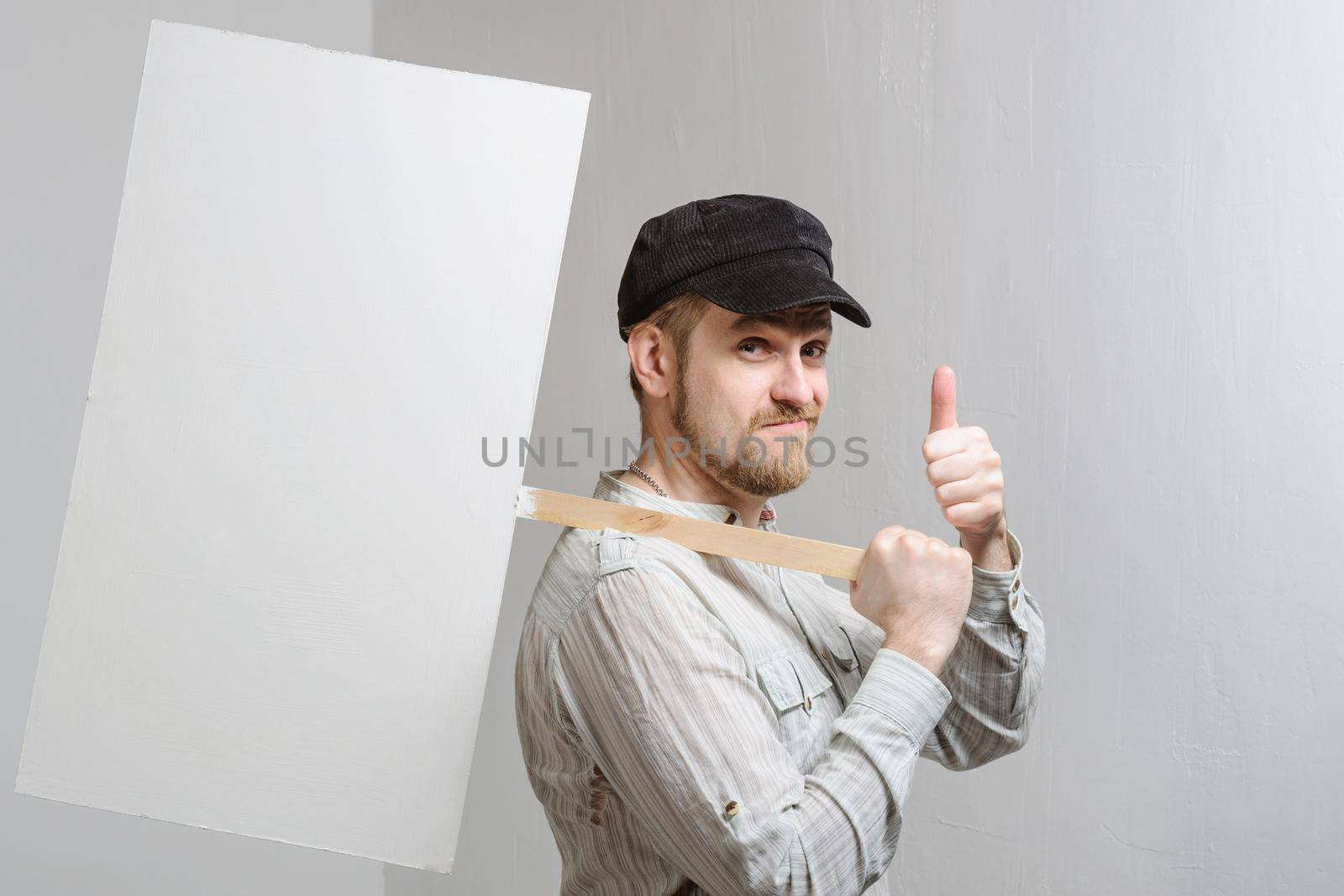 Amazed bearded man showing thumb up and leaning at copy space while standing against white background