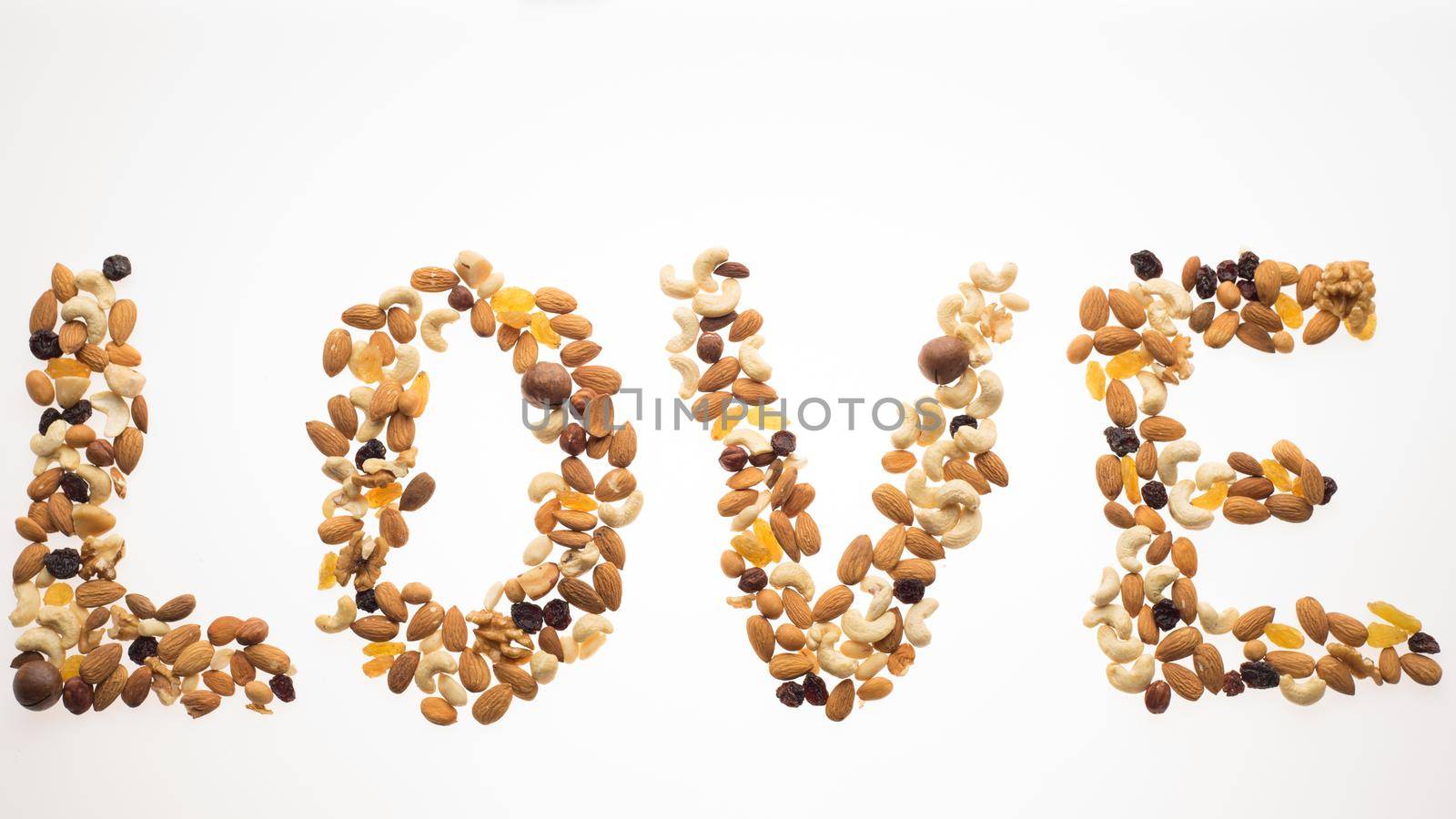The word love laid out from a mix of nuts on a white background. Healthy lifestyle concept.