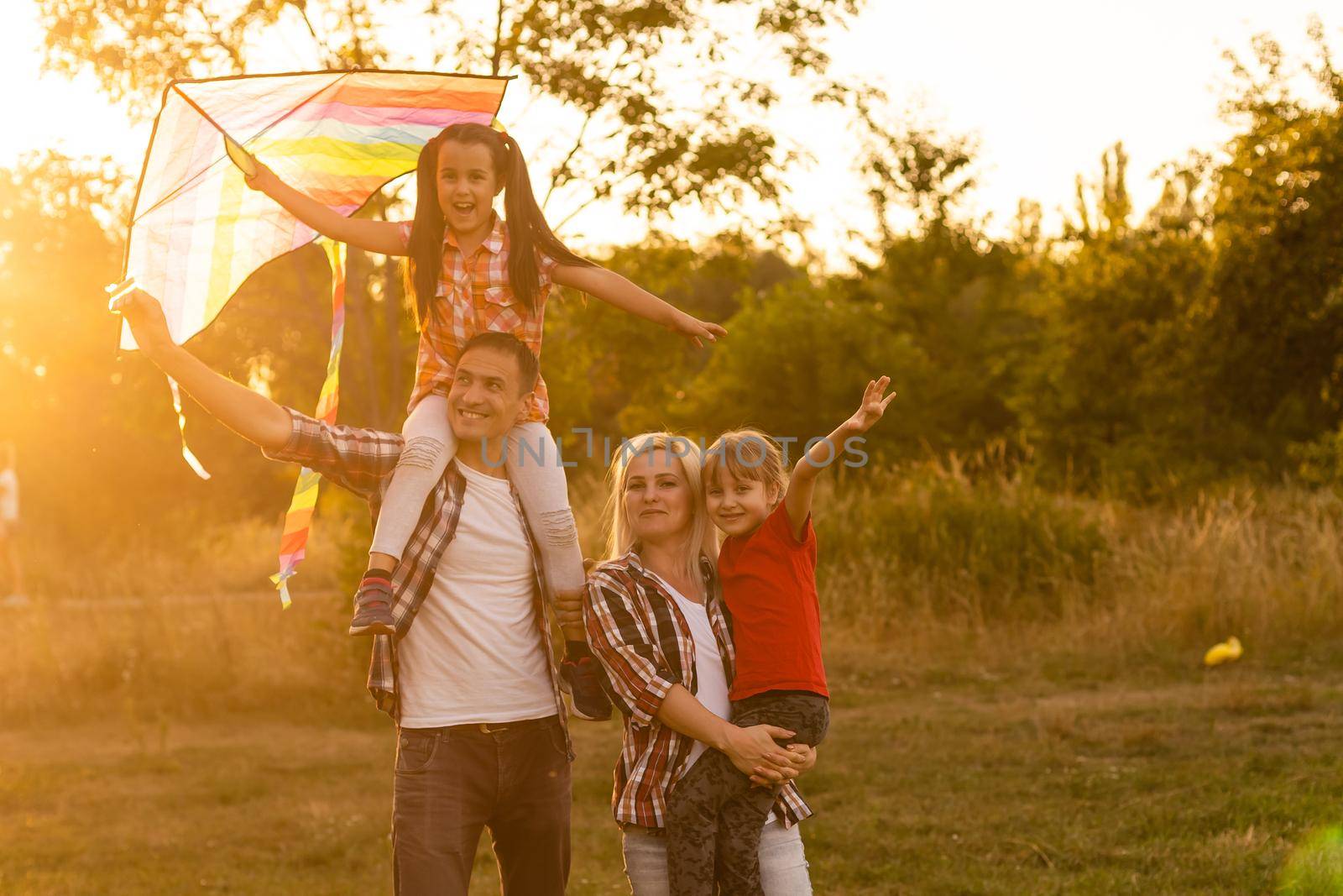 Happy family walking in field and looking at sunset by Andelov13