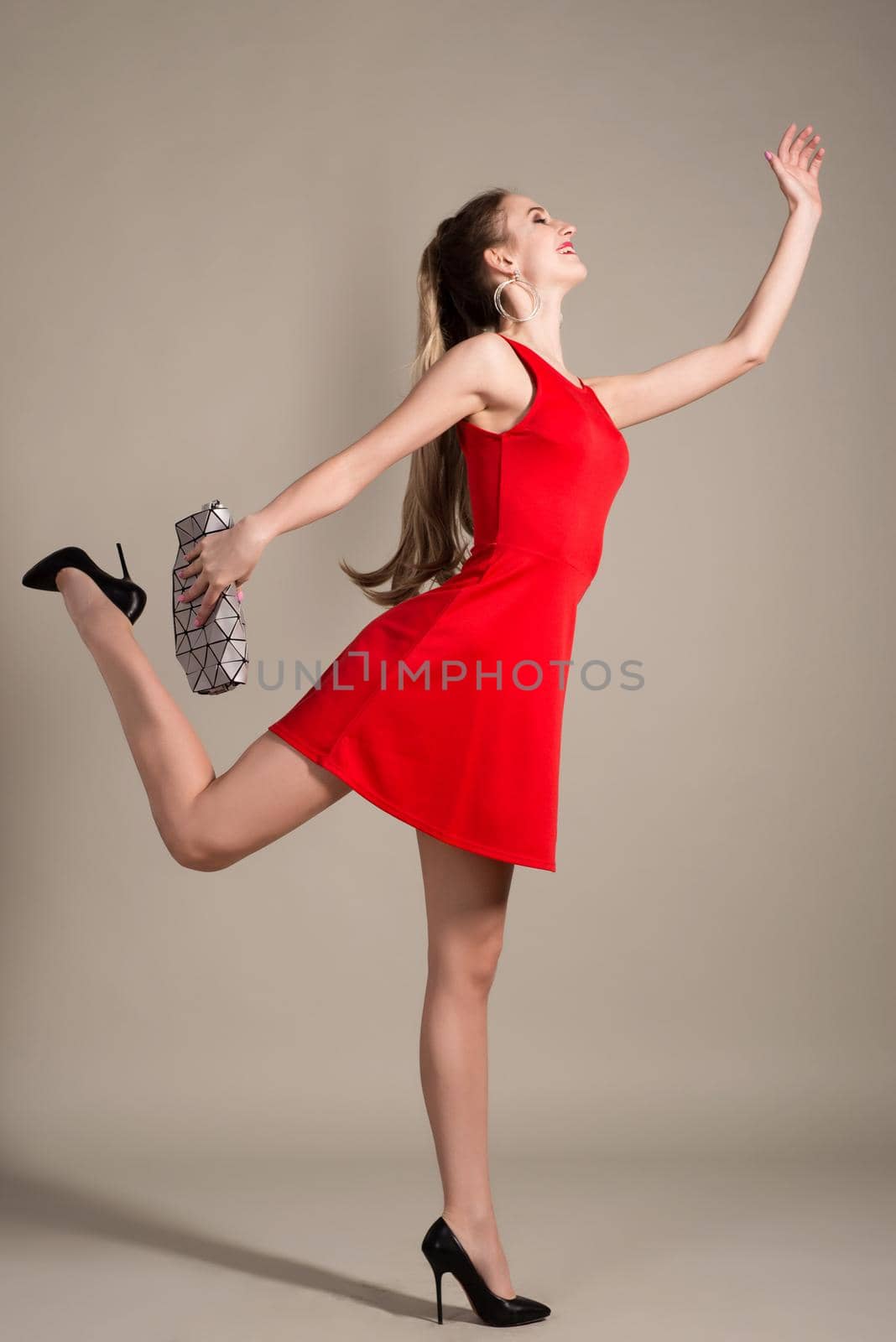 Shopper girl in red dress holding handbag runs isolated on gray background by zartarn