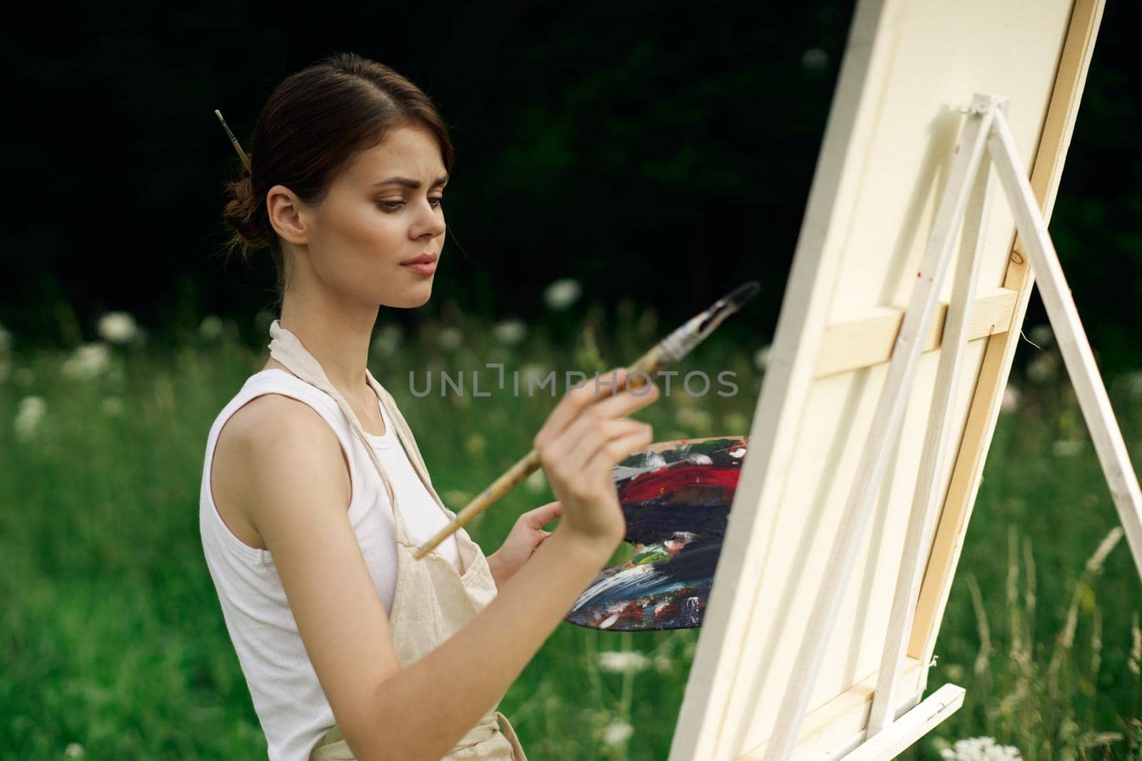 cheerful woman artist painting a picture outdoors creative art by Vichizh