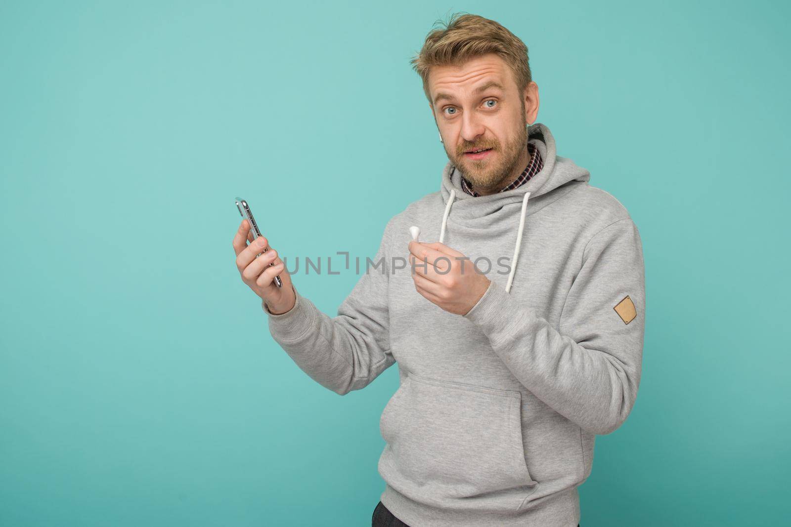 Tula, Russia - May 1, 2019: Happy Man listening music Apple AirPods wireless . by zartarn