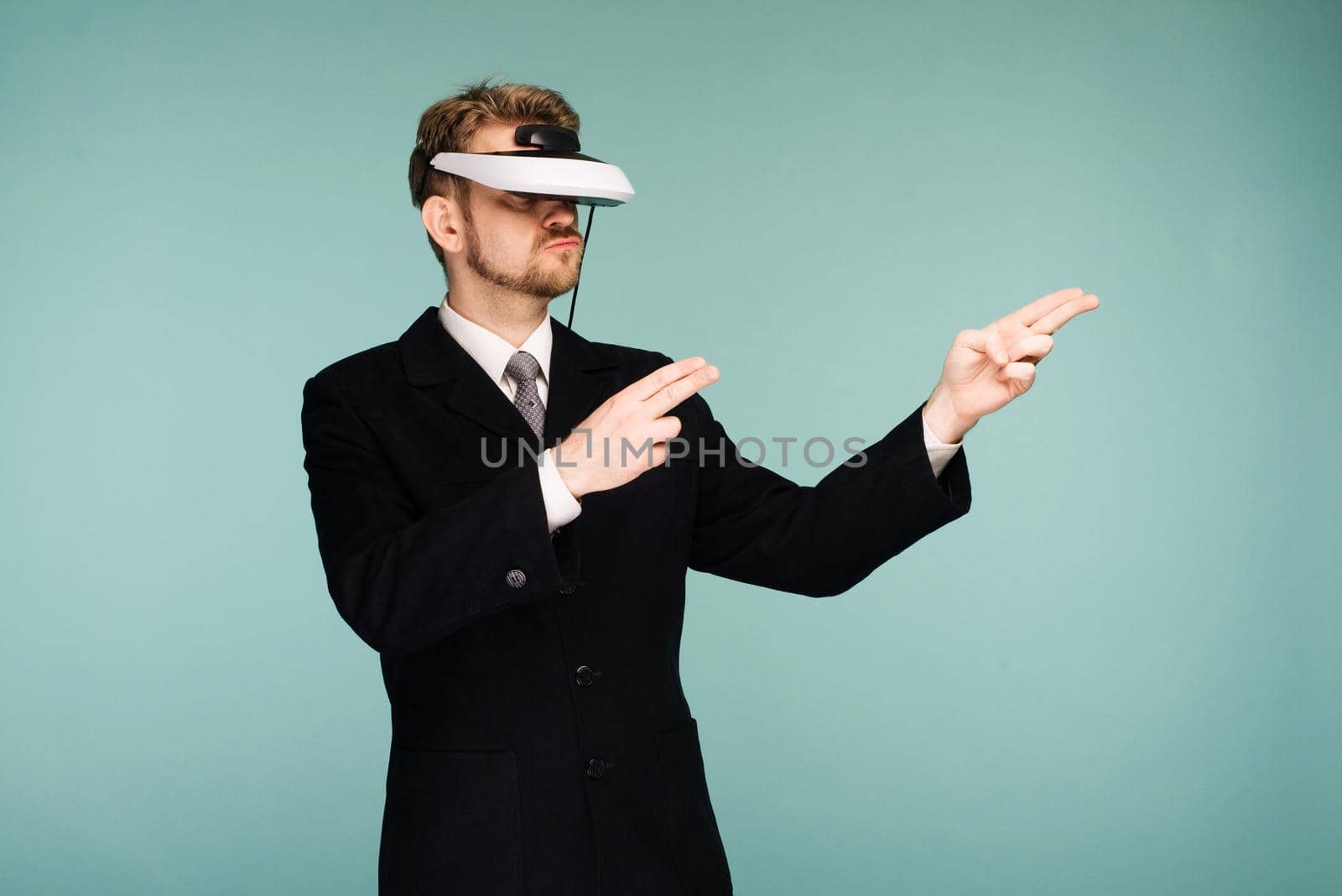 Businessman in a formal wear wearing virtual reality glasses pointing fingers away by zartarn