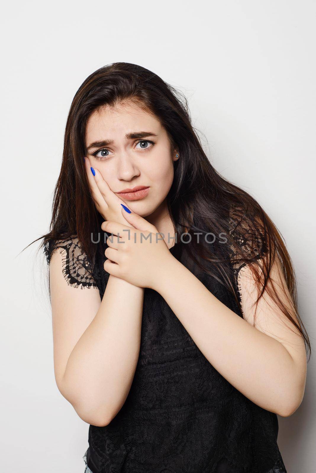 young woman has a toothache, studio photo isolated on a gray background by zartarn