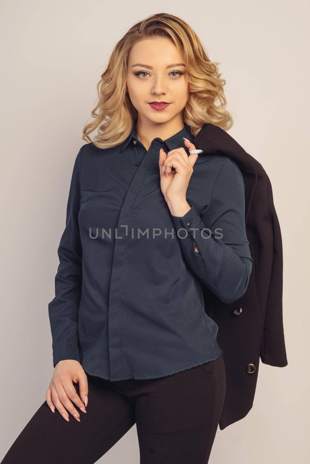 young business lady is standing holding a jacket on her shoulder isoleted