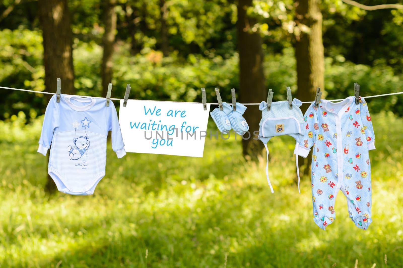 newborn Things hanging from a rope outside with the inscription plaque We are waiting for you