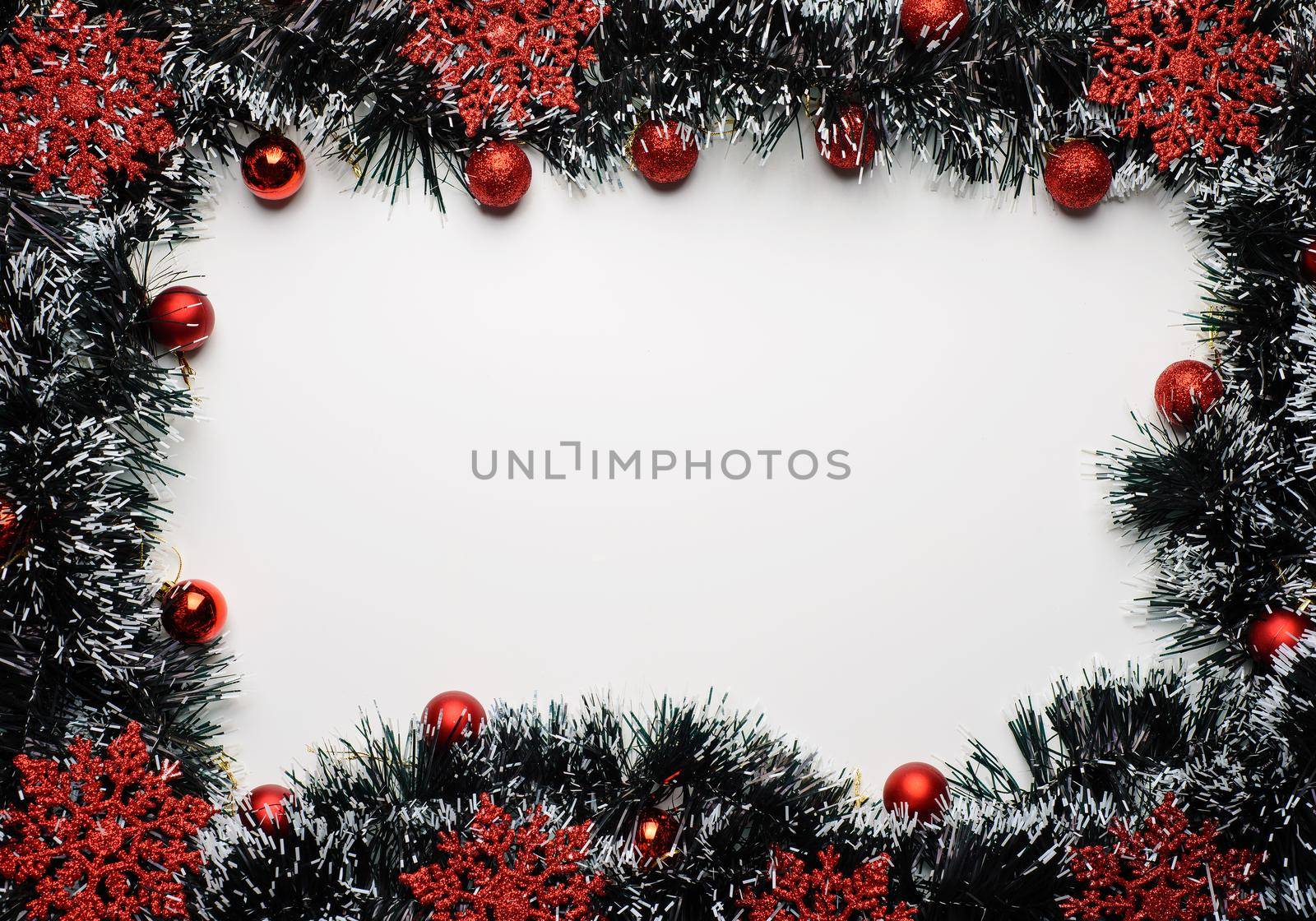 Space for New Year's wishes with tinsel and red ornaments and balls.