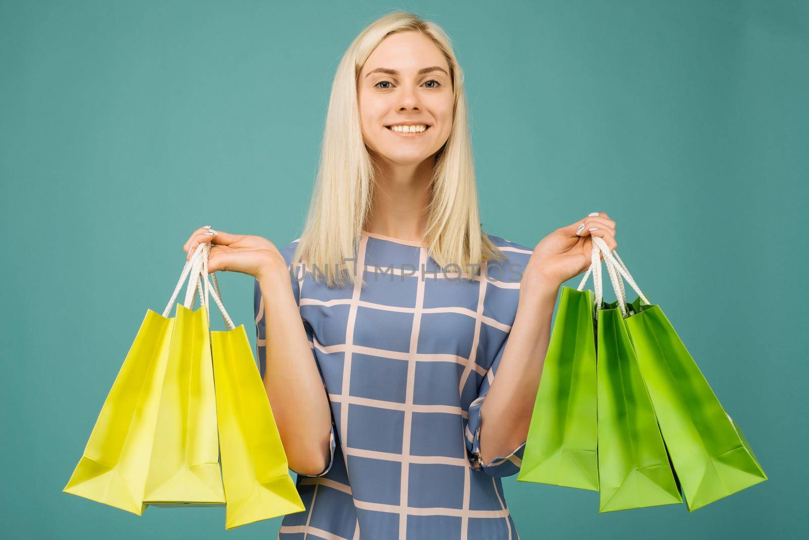 Happy girl in a checkered blouse holds shopping bags by zartarn