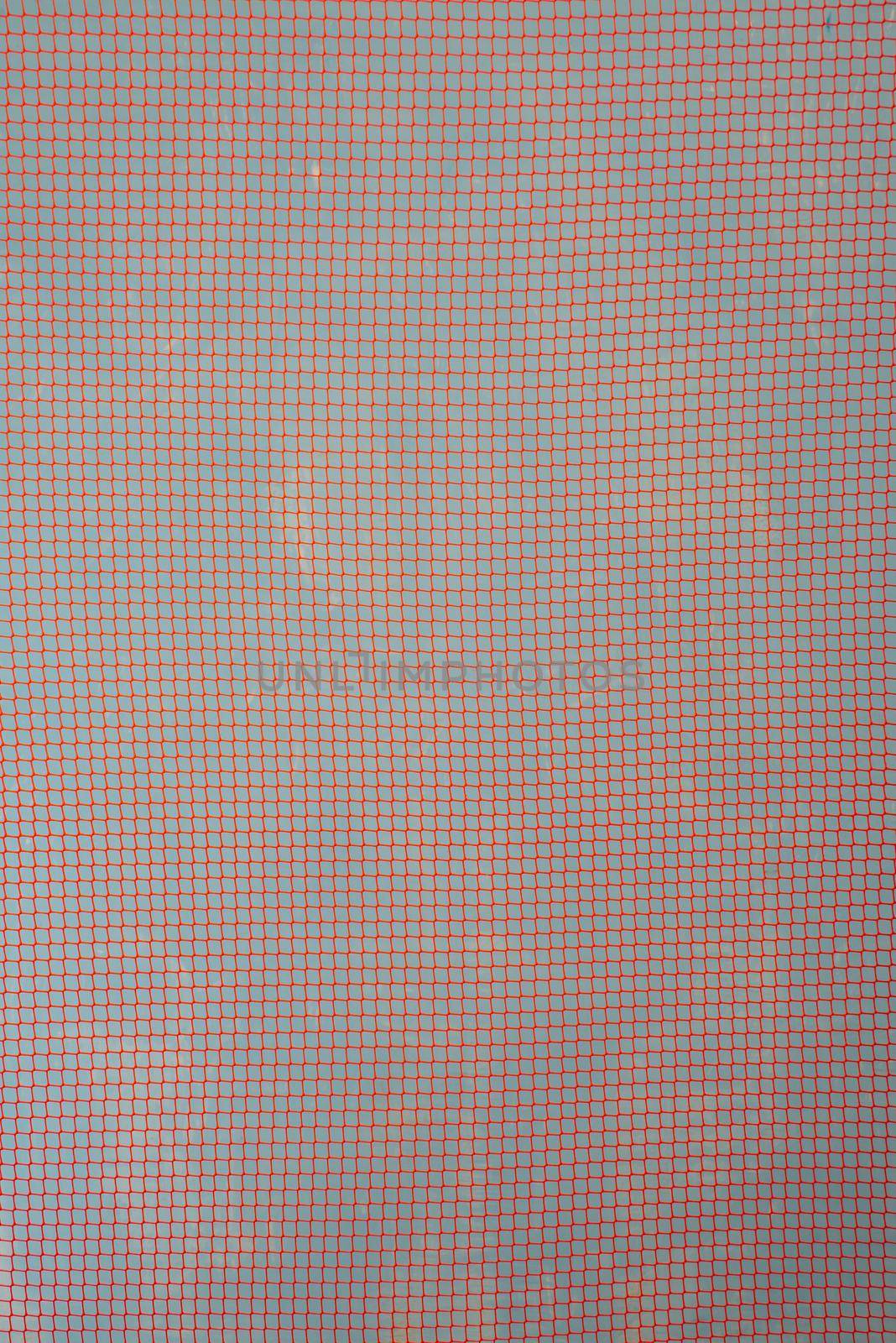 orange garden plastic fence mesh isolated on blue background.