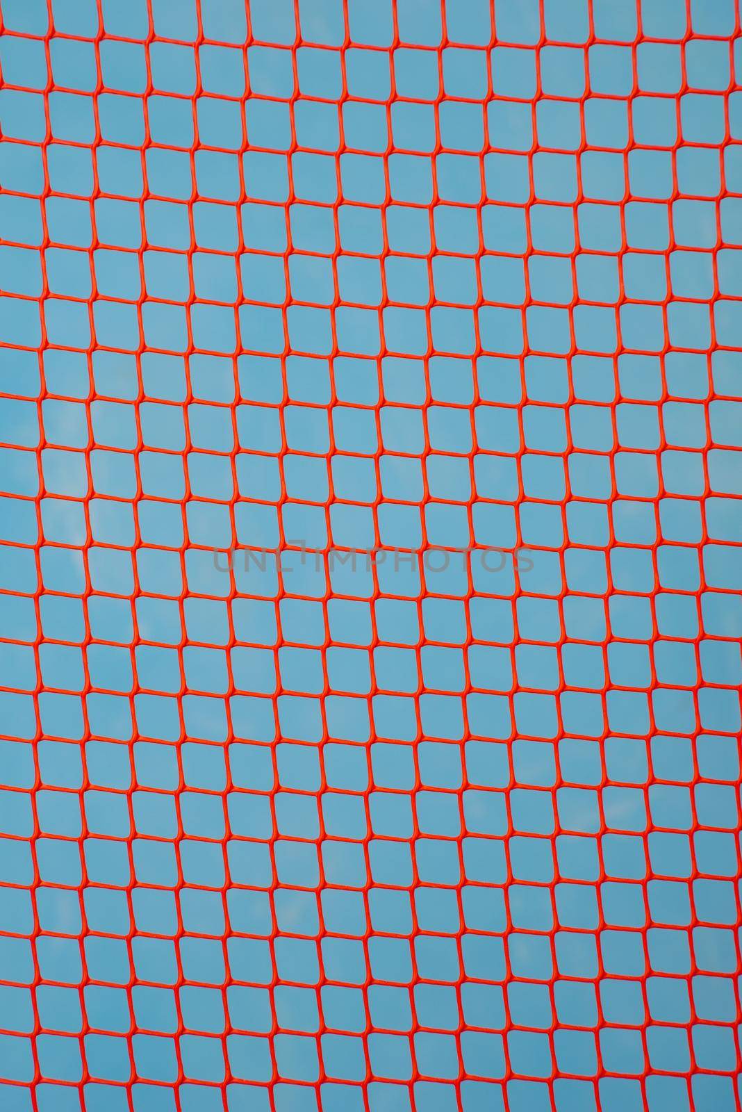 orange garden plastic fence mesh isolated on blue background.