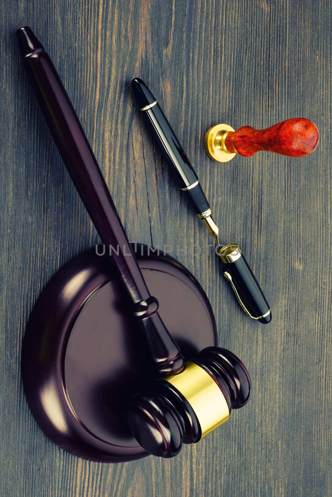 Judge's gavel, fountain pen and a stamp on an old wooden table - Image