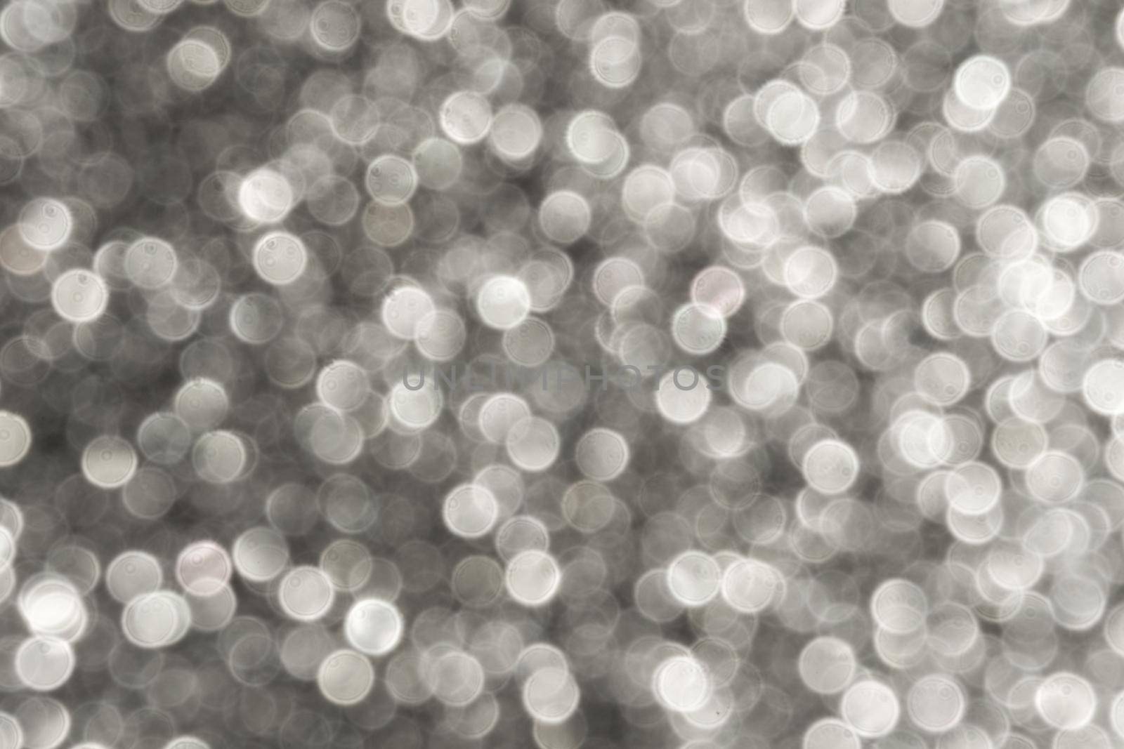 Silver Sparkling Lights Festive background with texture. Abstract Christmas twinkled bright bokeh defocused and Falling stars. Winter Card or invitation