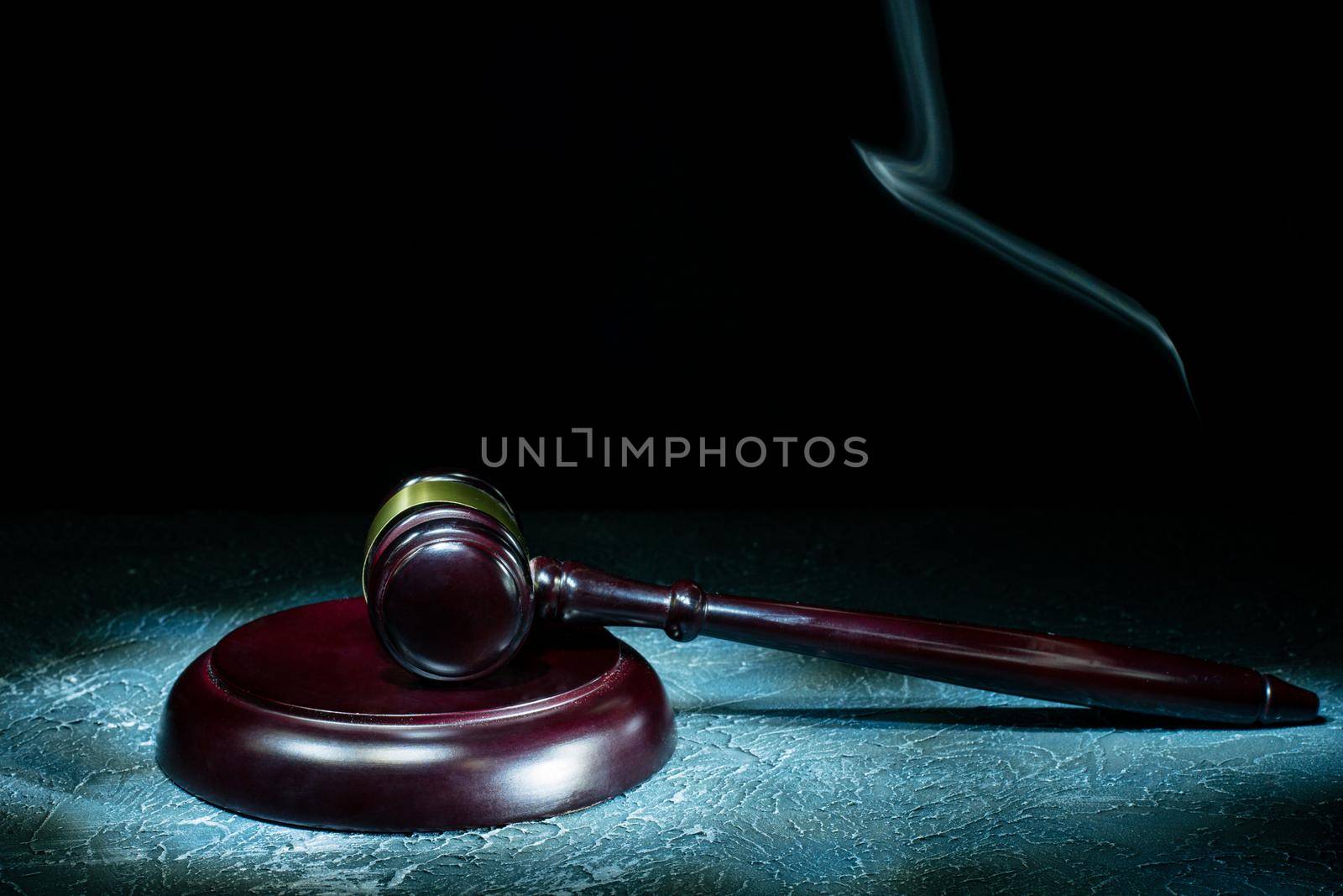 Judge's gavel lies on a stone table. Picture taken with a light brush - Image