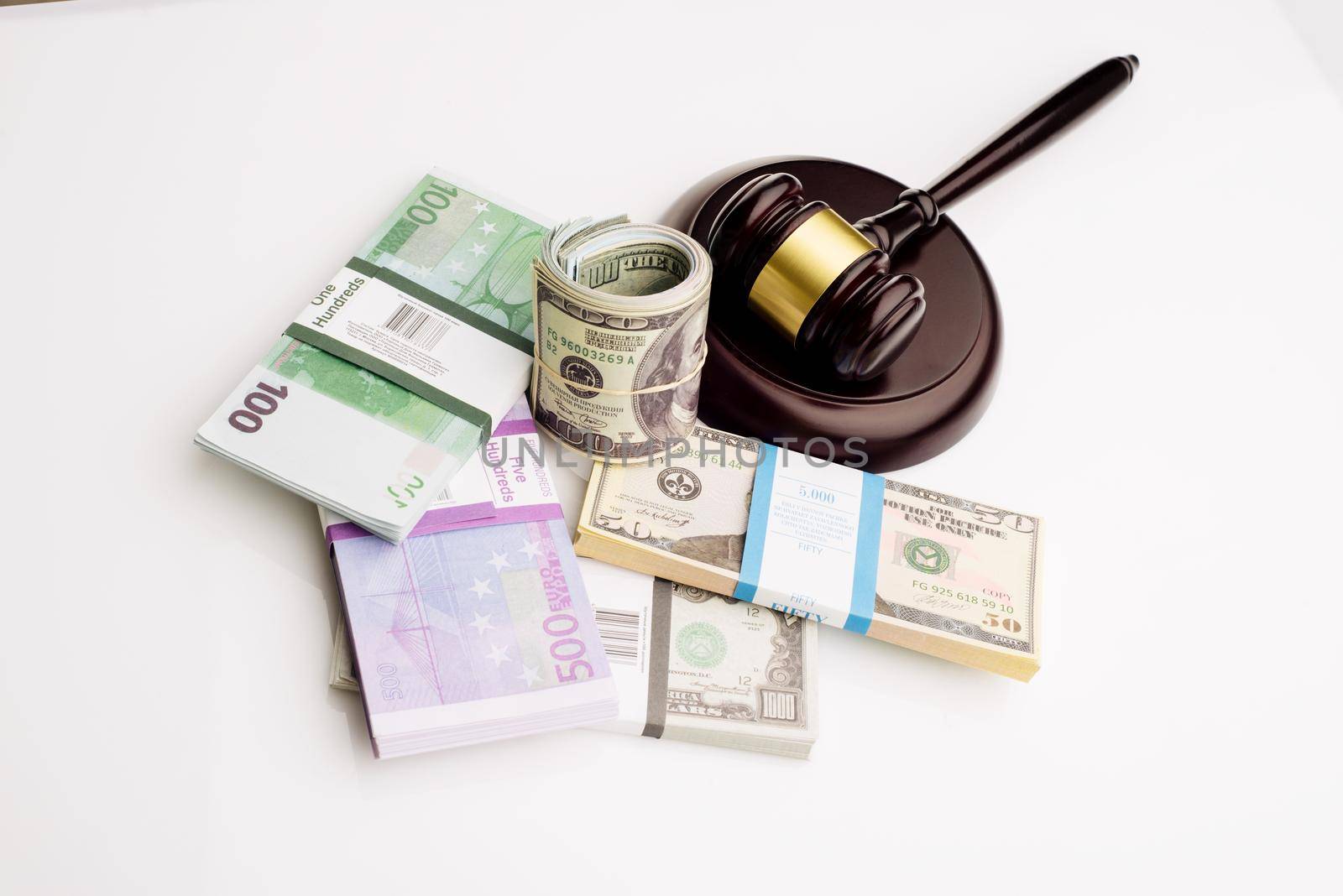 Top view Judge's gavel and packs of dollars and euro banknotes on a white background. The concept of growing national debt- image