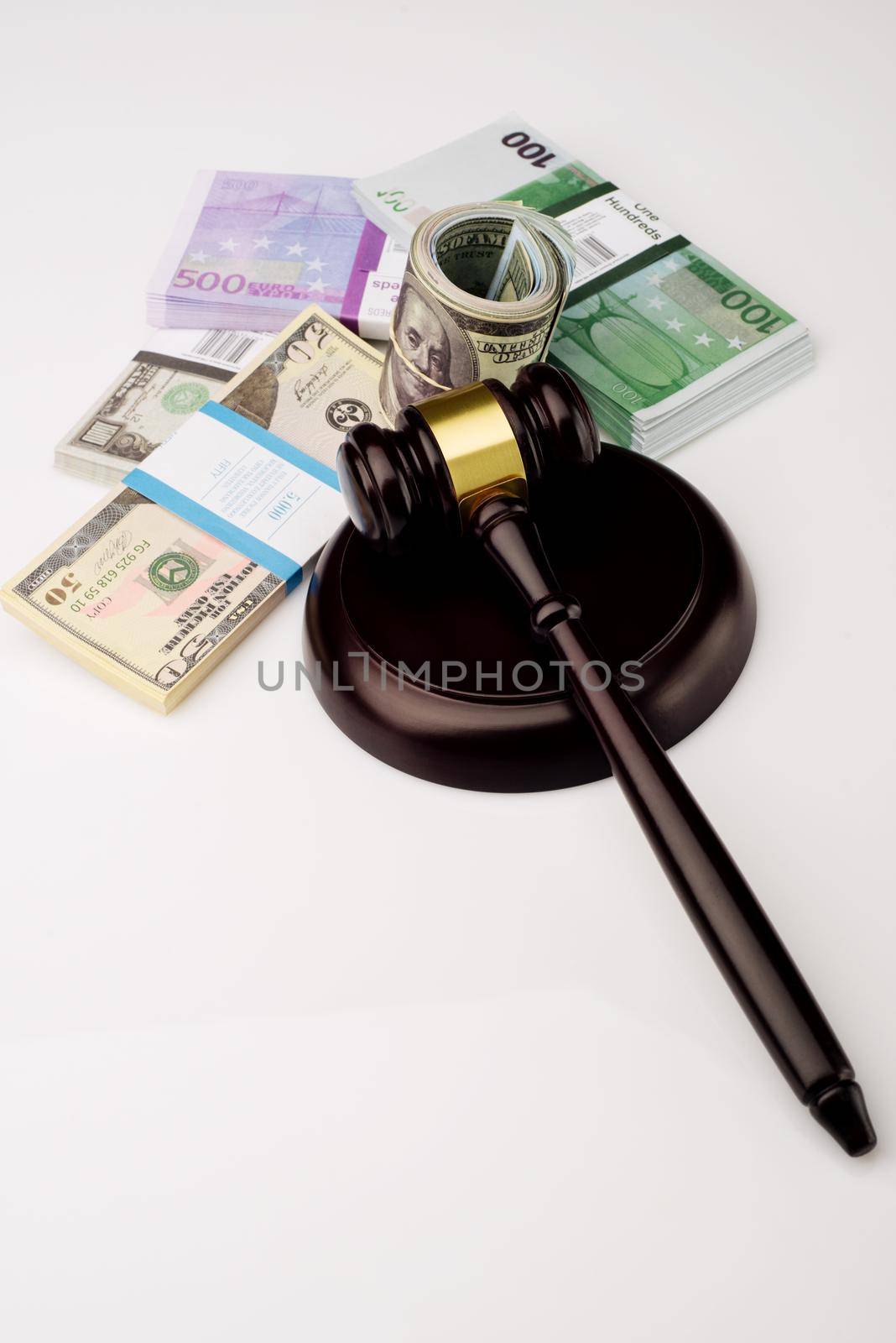 Top view Judge's gavel and packs of dollars and euro banknotes on a white background. The concept of growing national debt- image