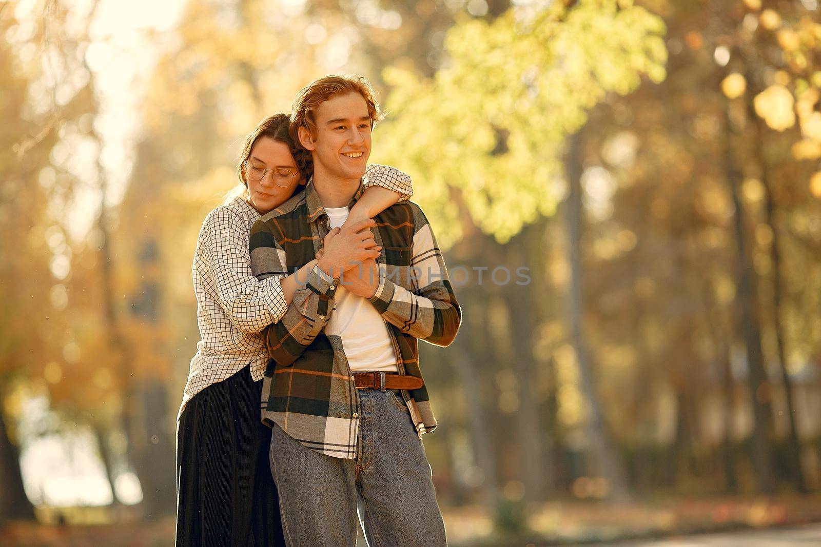 Couple in a park. Guy in a white t-shirt. Golden autumn.