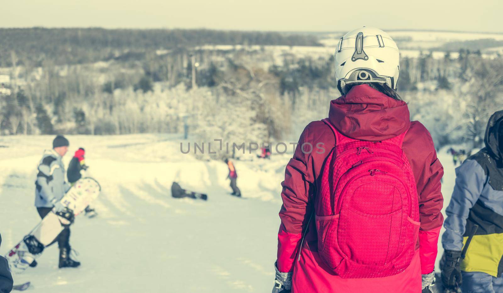 girl in ski suit on a snowhill view from back