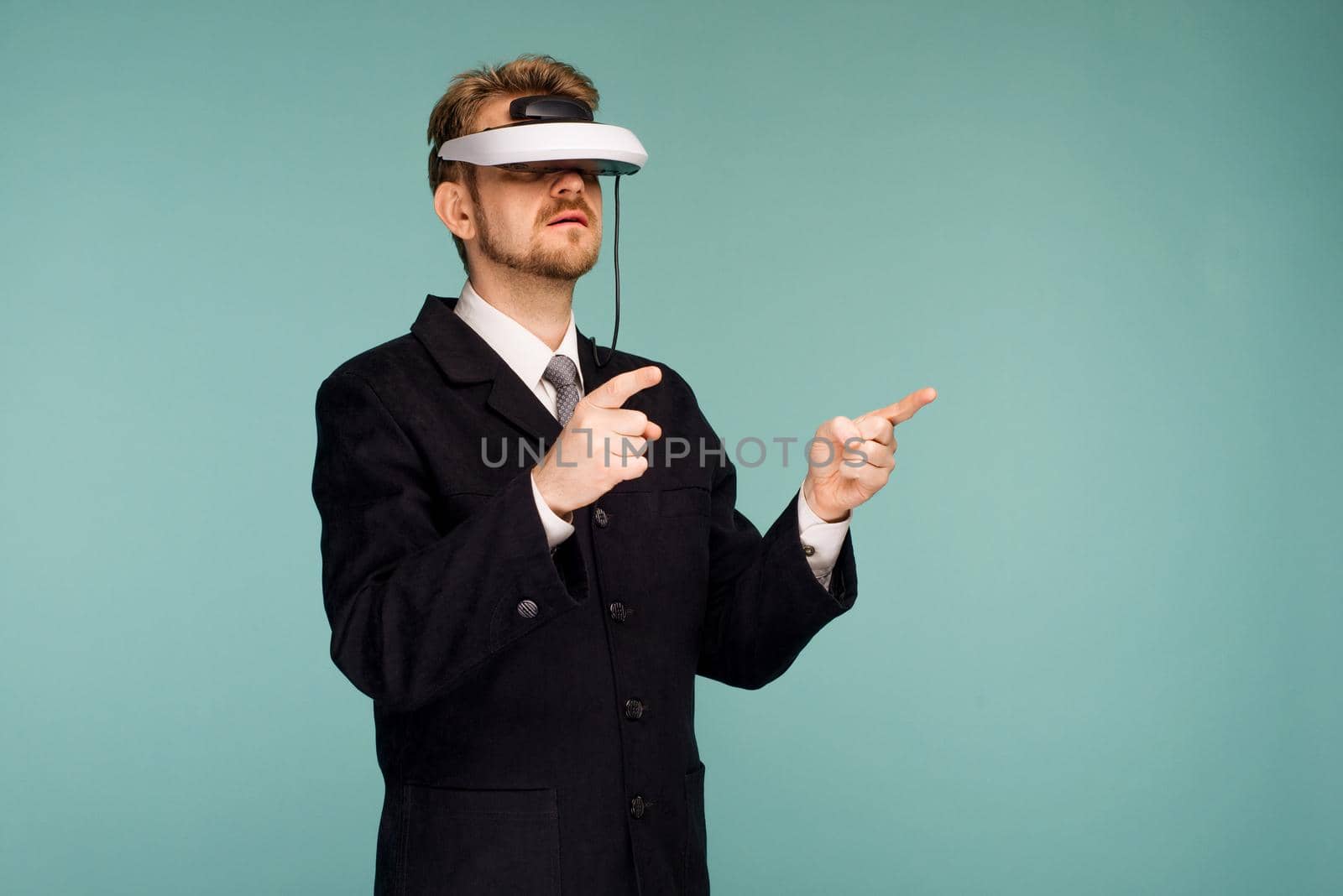 Businessman in a formal wear wearing virtual reality glasses pointing fingers away - image