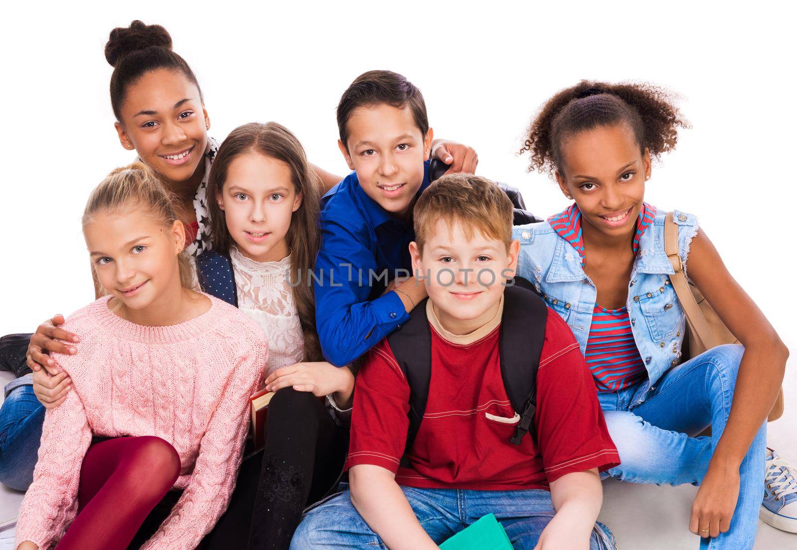 teenagers with different complexion together sitting on the floor isolated on white background