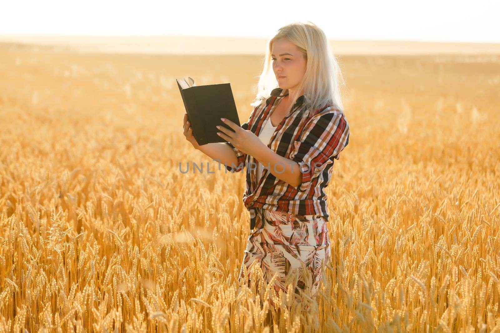 Woman holding a Bible, a natural field.