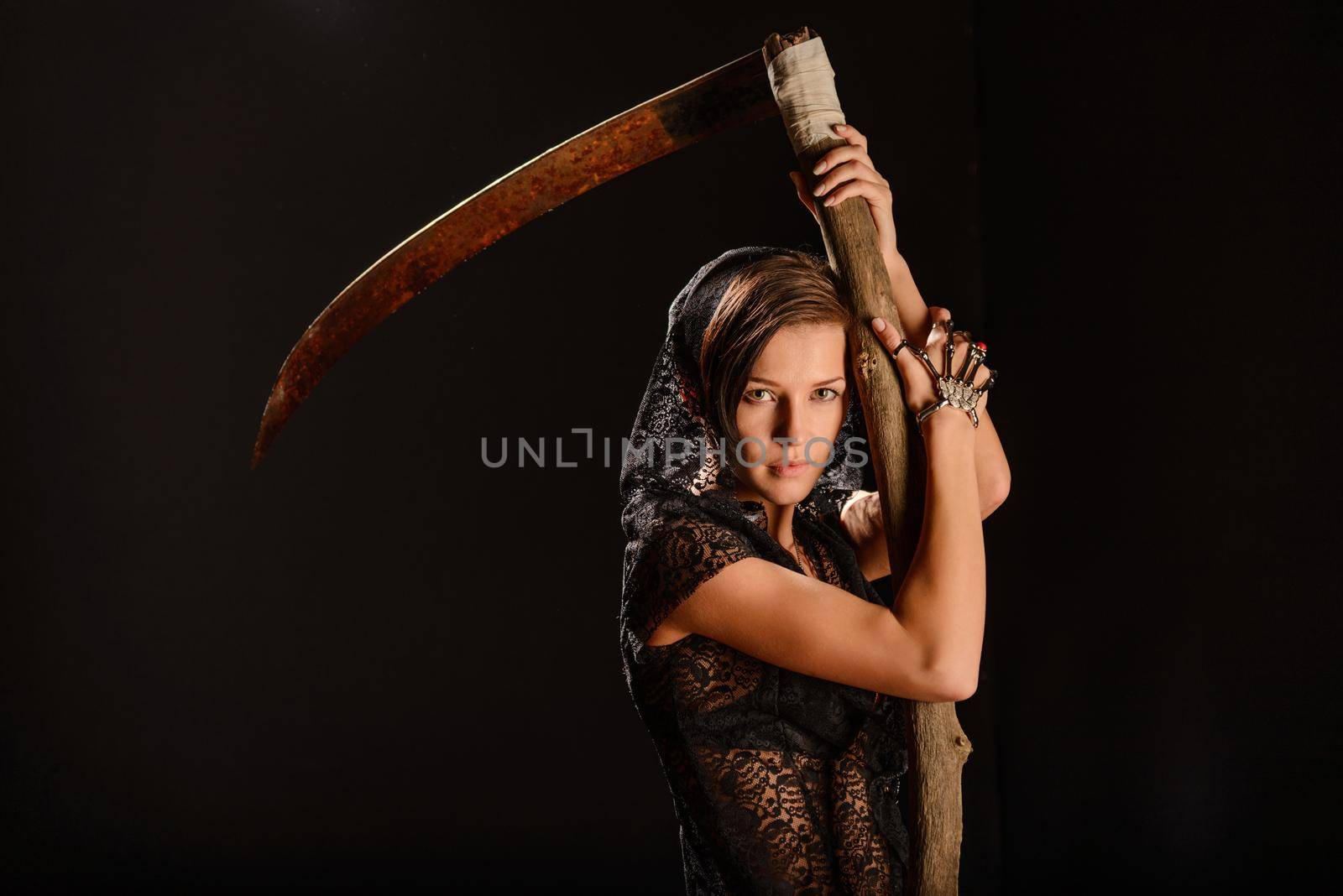 Girl in a black lace smock with a scythe of death. concept