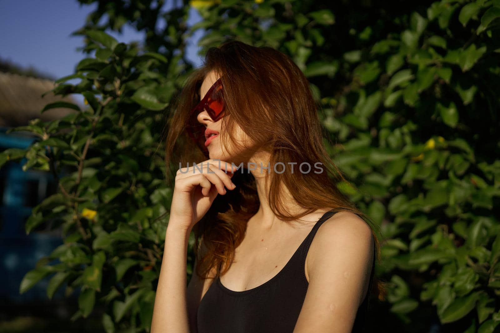 fashionable woman in sunglasses and green leaves summer exotic. High quality photo