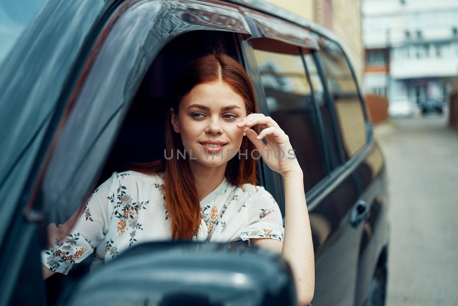 cheerful woman driving a car looks out of the window. High quality photo