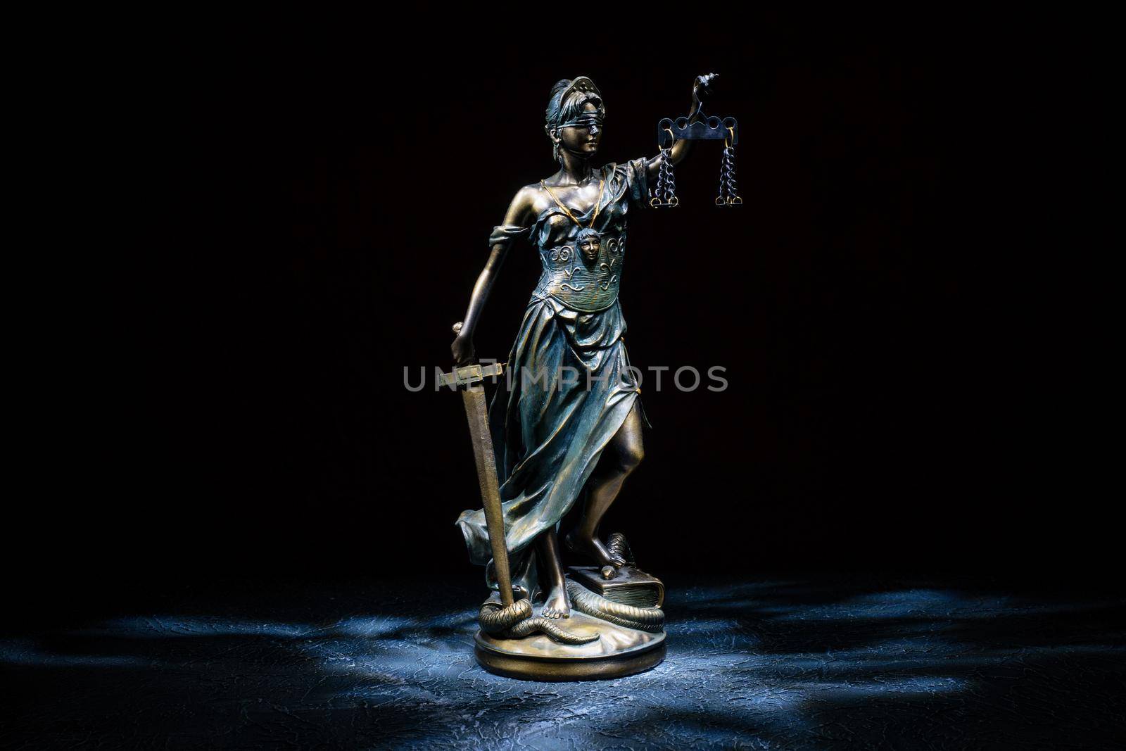 Themis statuette stands on the old vintage stone table. Picture taken with a light brush - Image