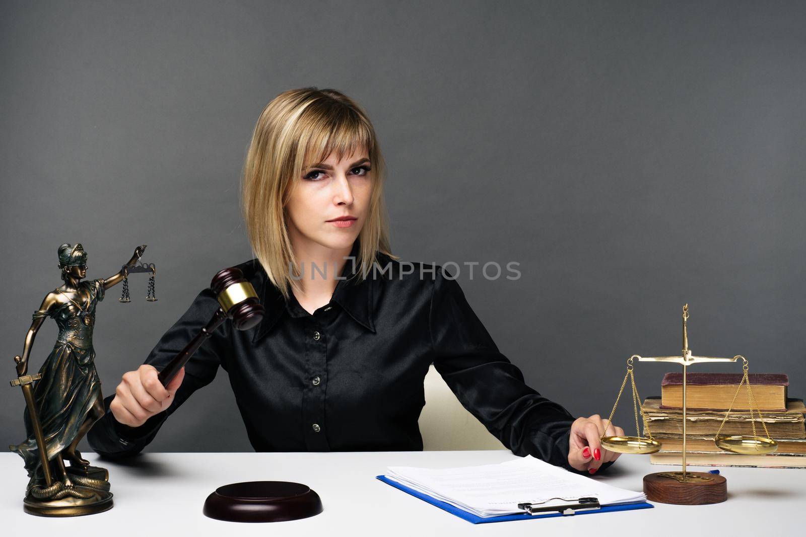 A young fair woman judge works in her office. - image