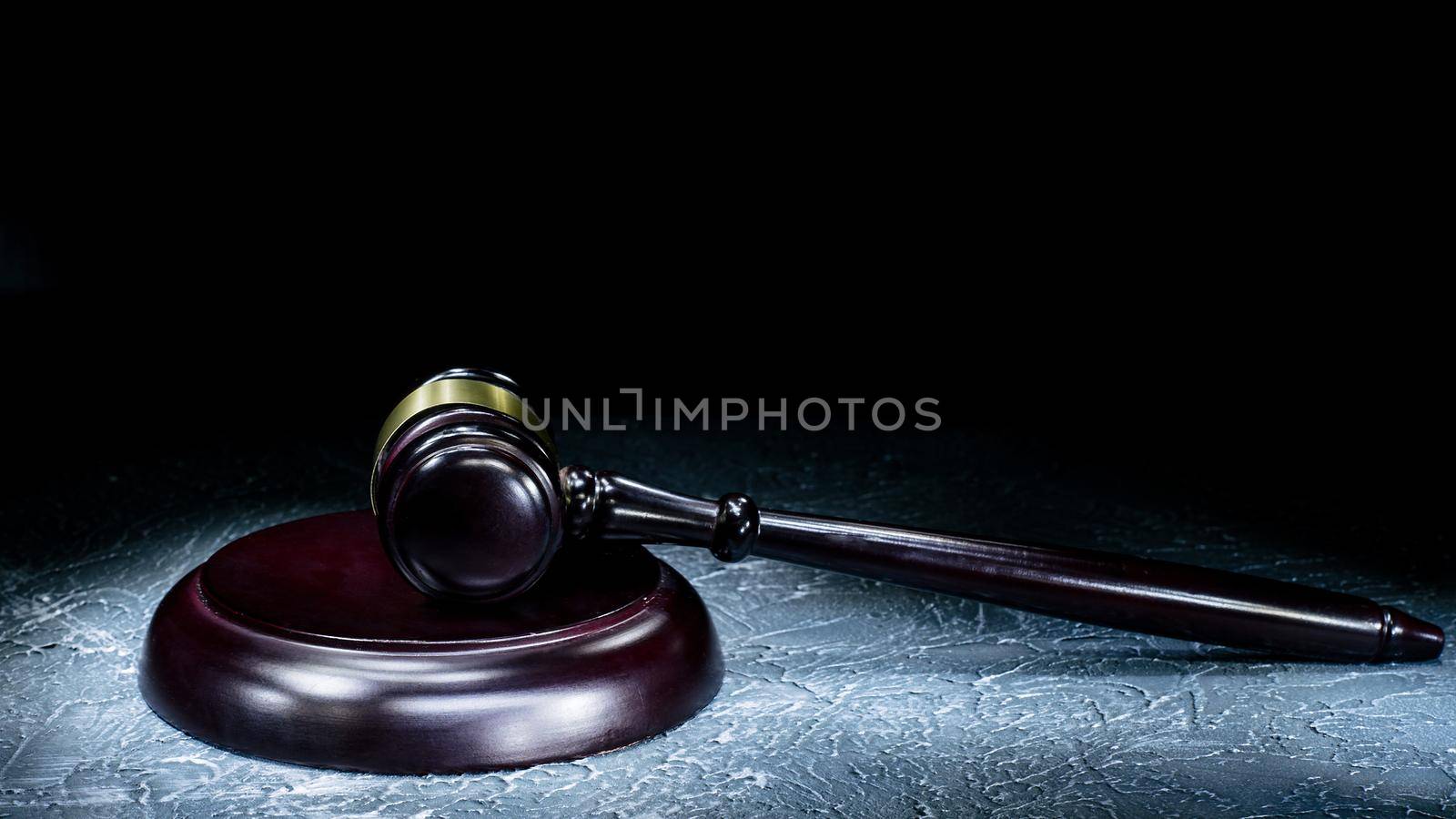 Judge's gavel lies on a stone table. Picture taken with a light brush - Image