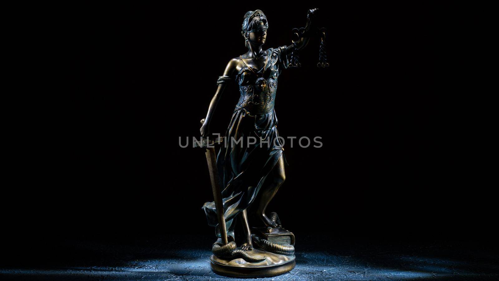 Themis statuette stands on the old vintage stone table. Picture taken with a light brush - Image