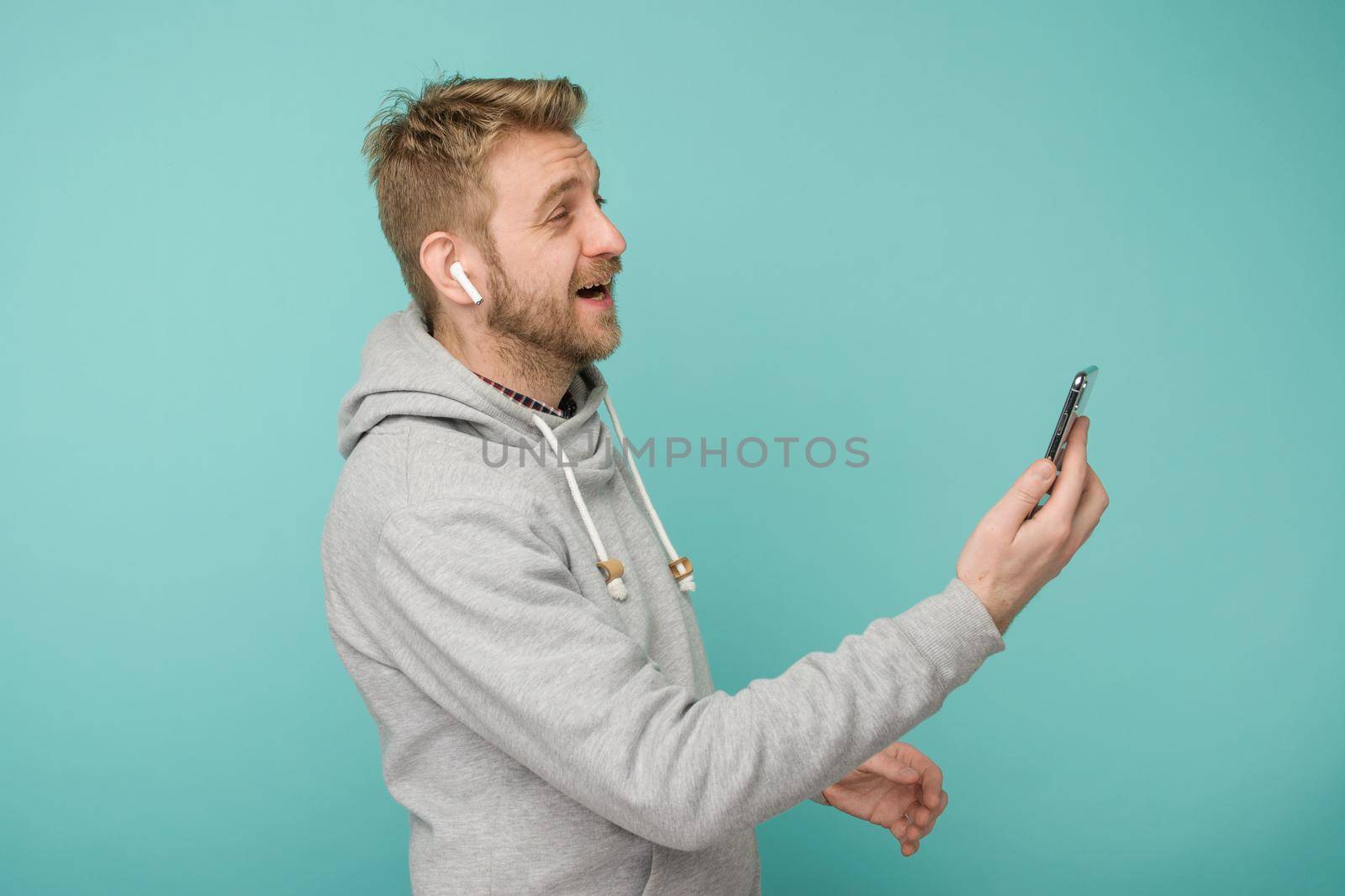 Tula, Russia - May 1, 2019: Happy Man listening music Apple AirPods wireless . by zartarn