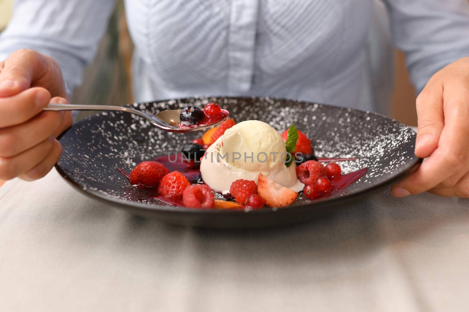 Woman eating panna cotta in a restaurant