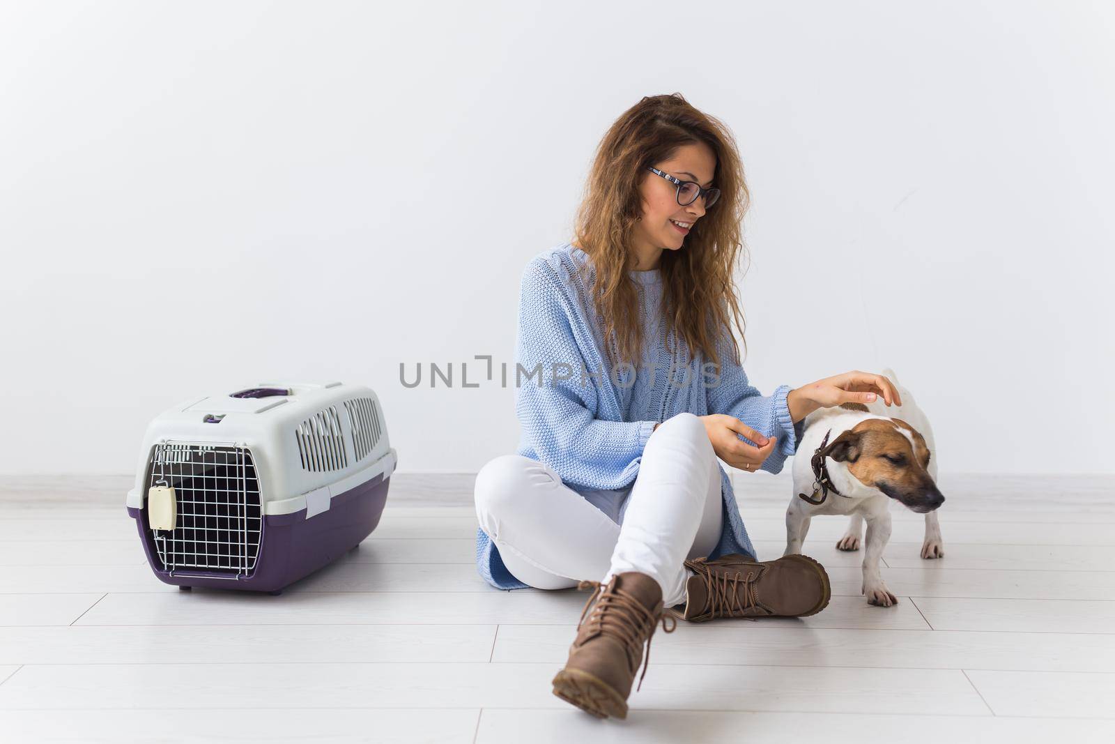 Dog carrying bags and pets owner concept - Attractive cheerful female in blue sweater playing with her favourite pet. Happy woman with her jack russell terrier by Satura86