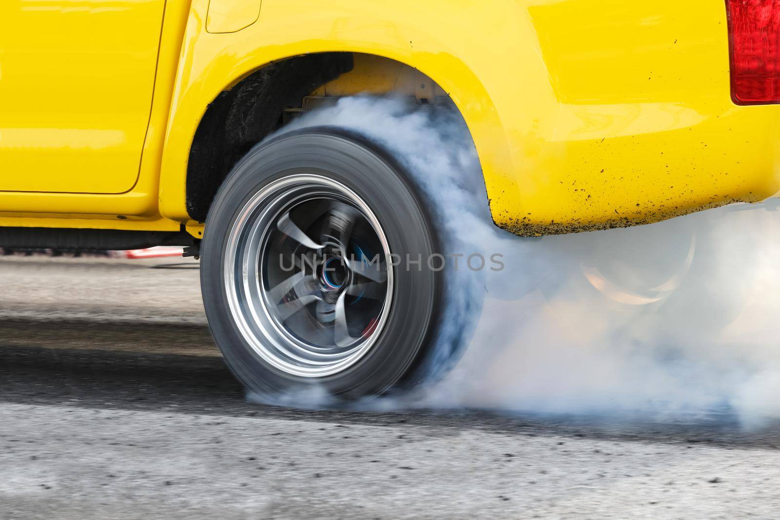 Drag racing car burns rubber off its tires in preparation for the race