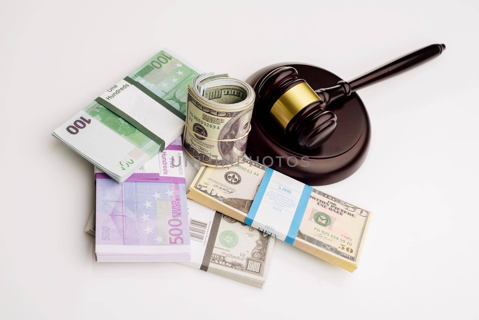 Top view Judge's gavel and packs of dollars and euro banknotes on a white background by zartarn