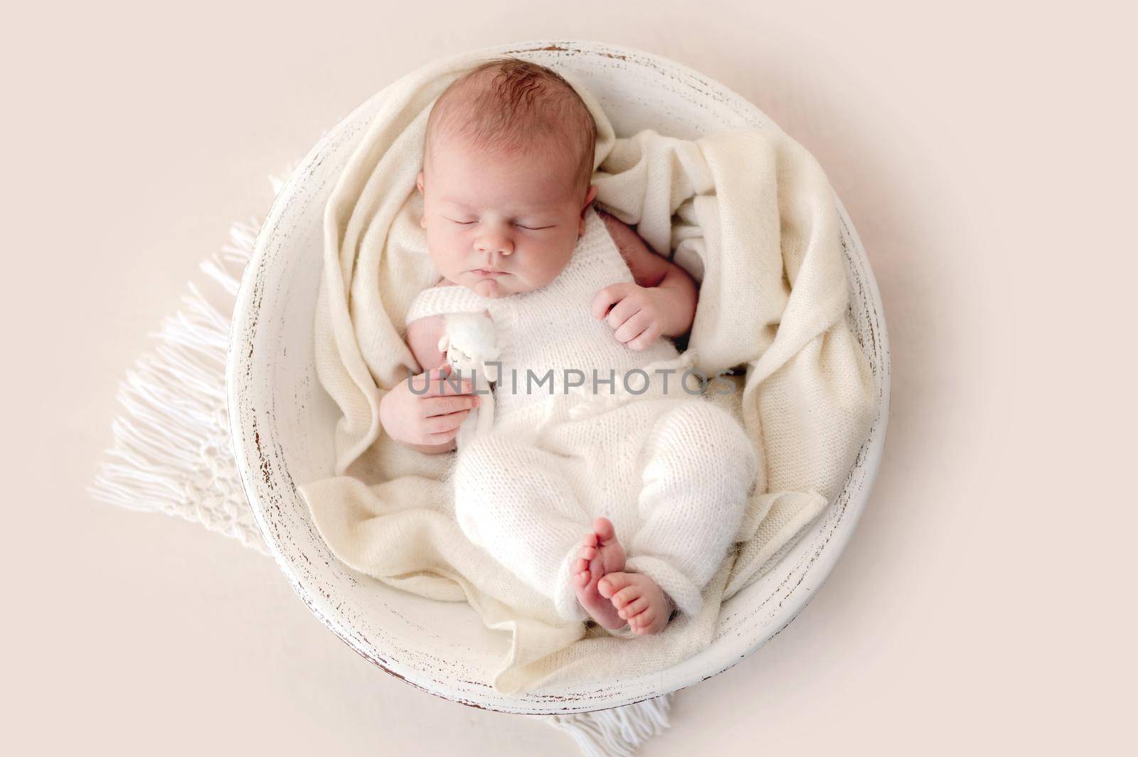 Newborn baby boy sleeping in designed basin. Adorable infant child kid napping during studio photoshoot